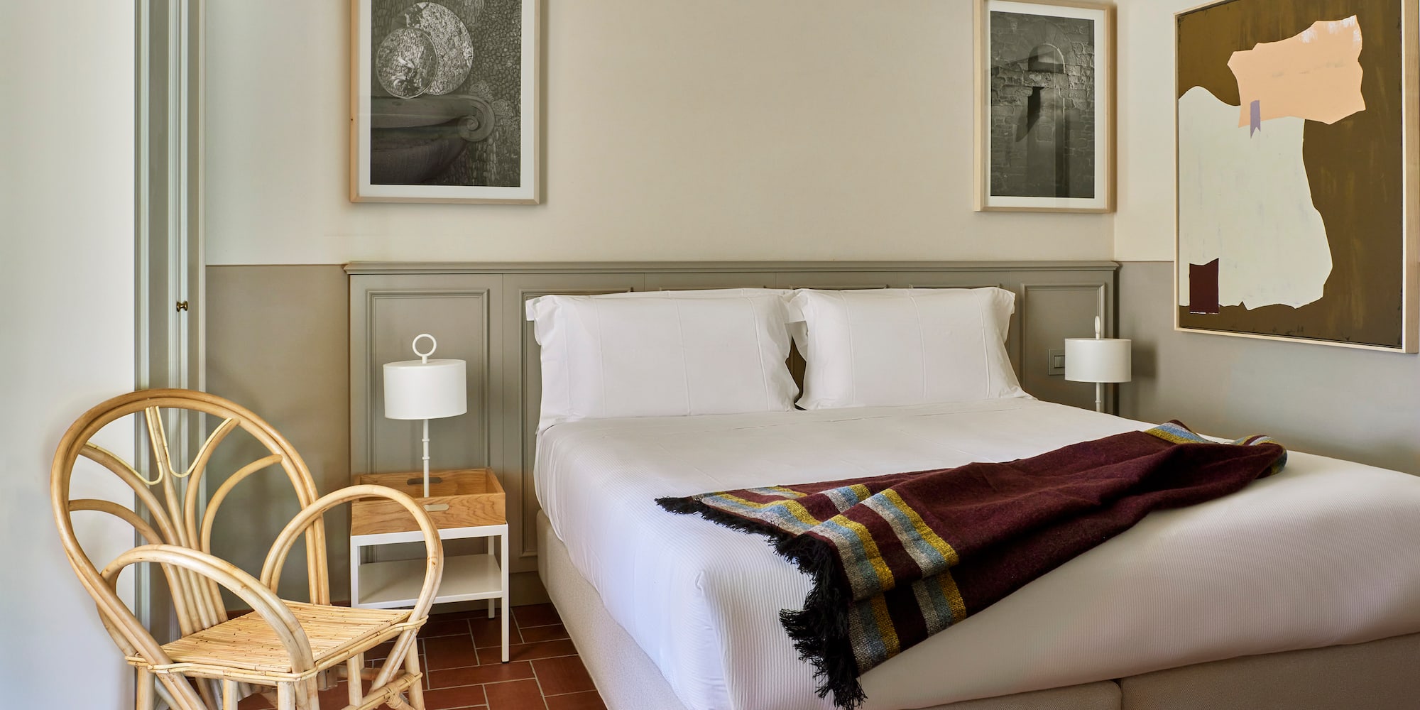 a bed with a blanket and a chair in a room