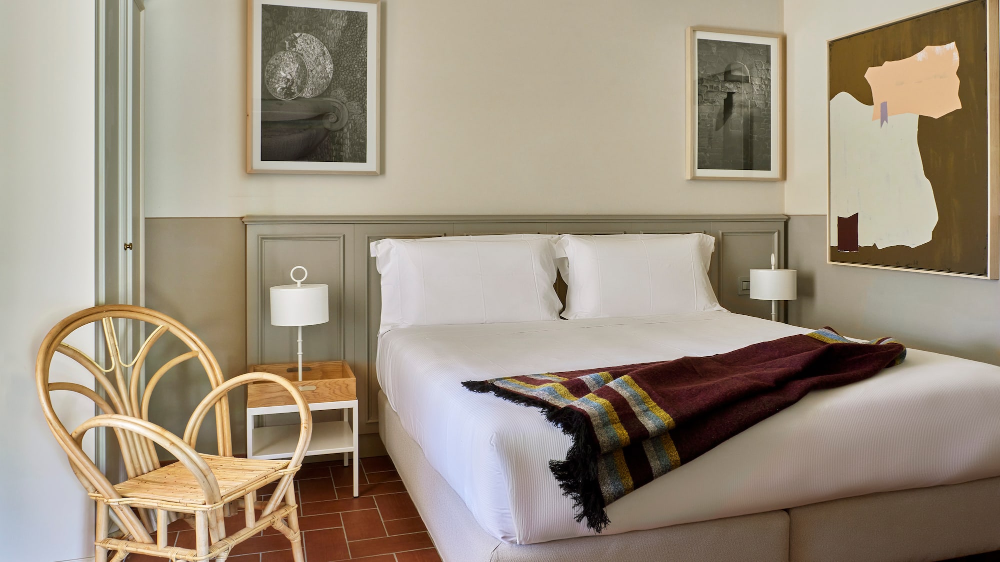 a bed with a blanket and a chair in a room