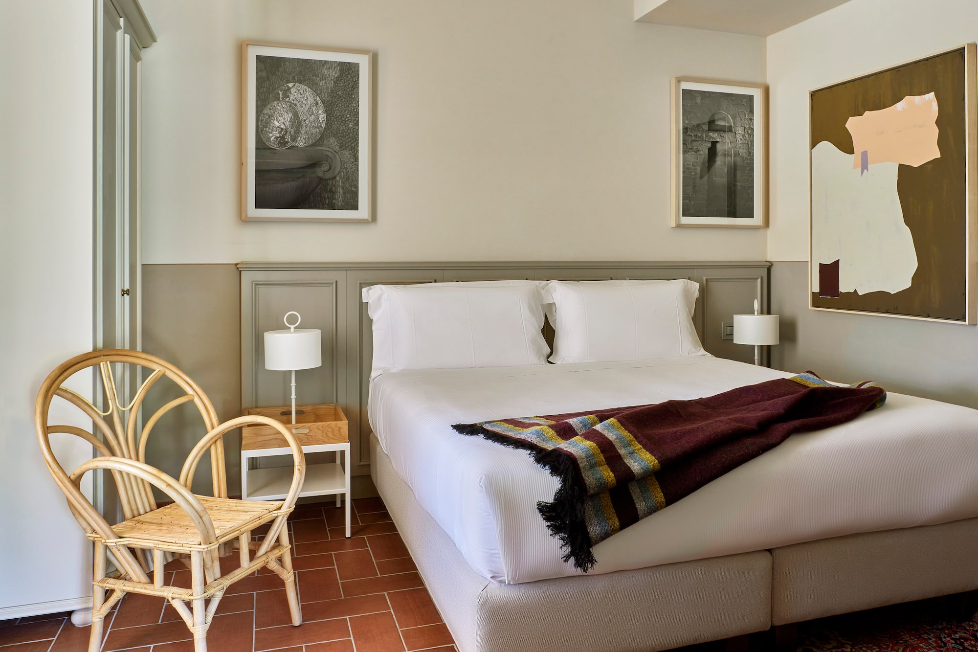 a bed with a blanket and a chair in a room