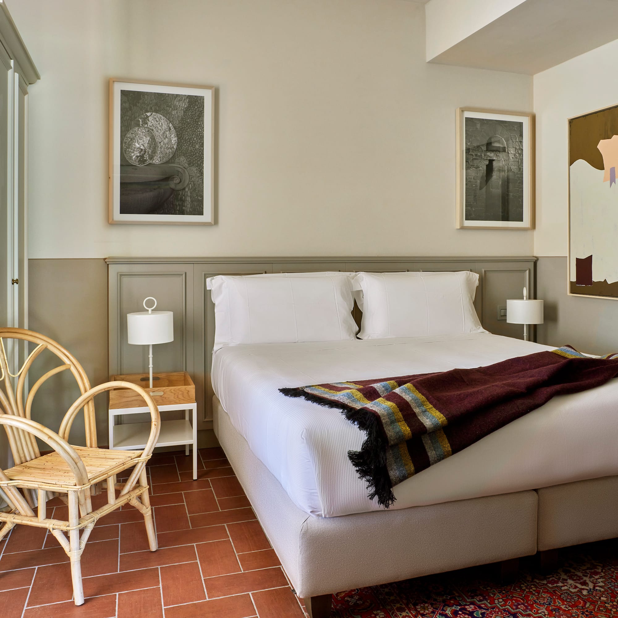 a bed with a blanket and a chair in a room