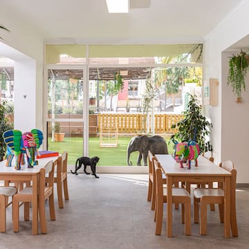 a room with tables and chairs and a dog outside