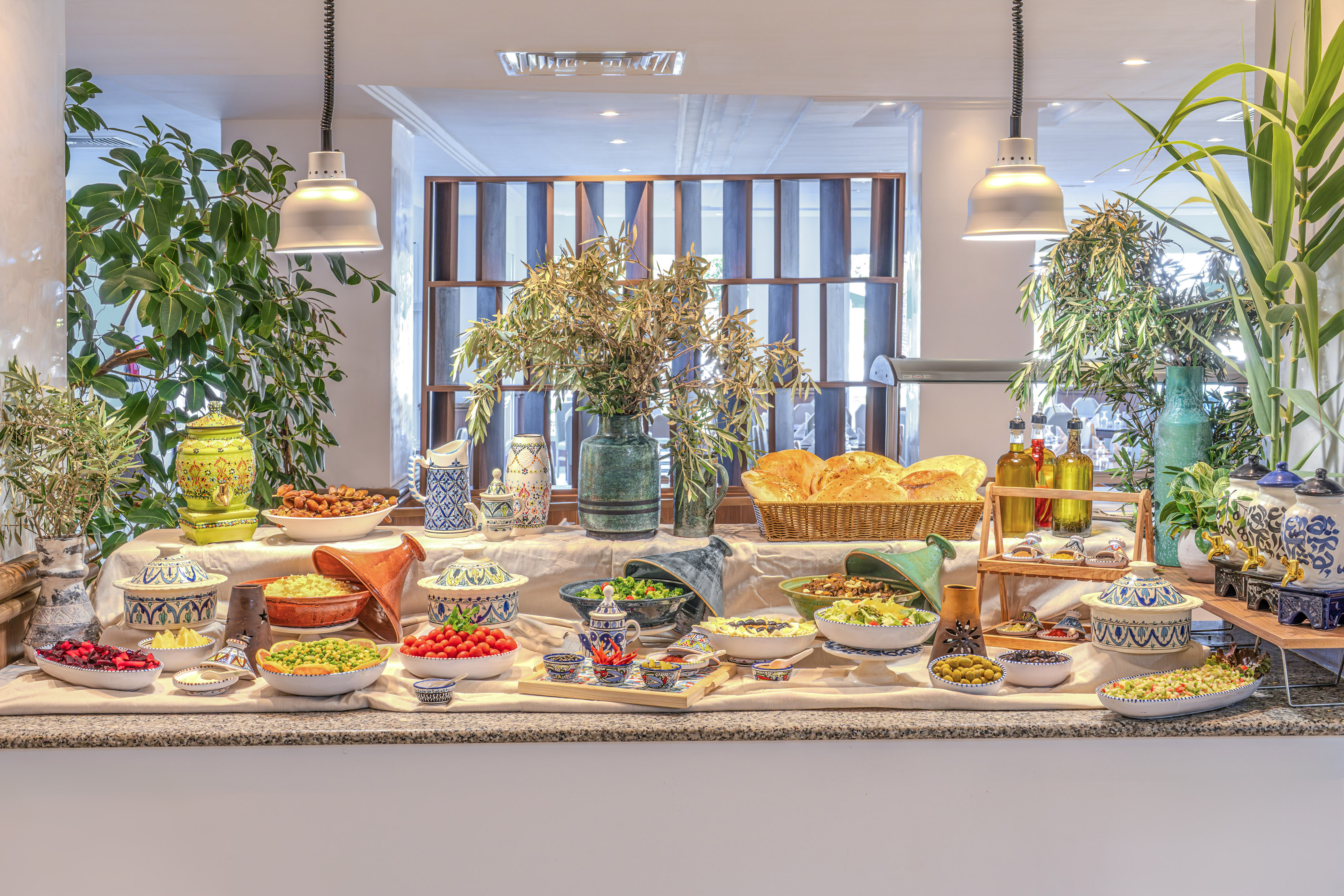 Buffet de comida marroquí con ensaladas, pan, tajines y aceitunas.
