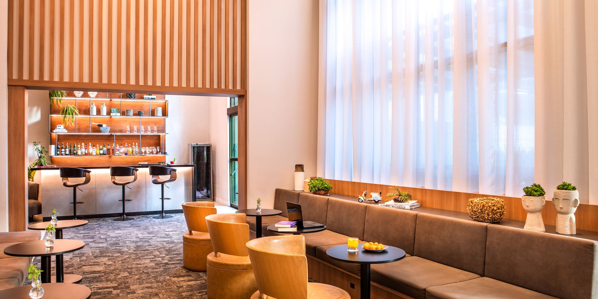 a room with a long couch and tables and chairs