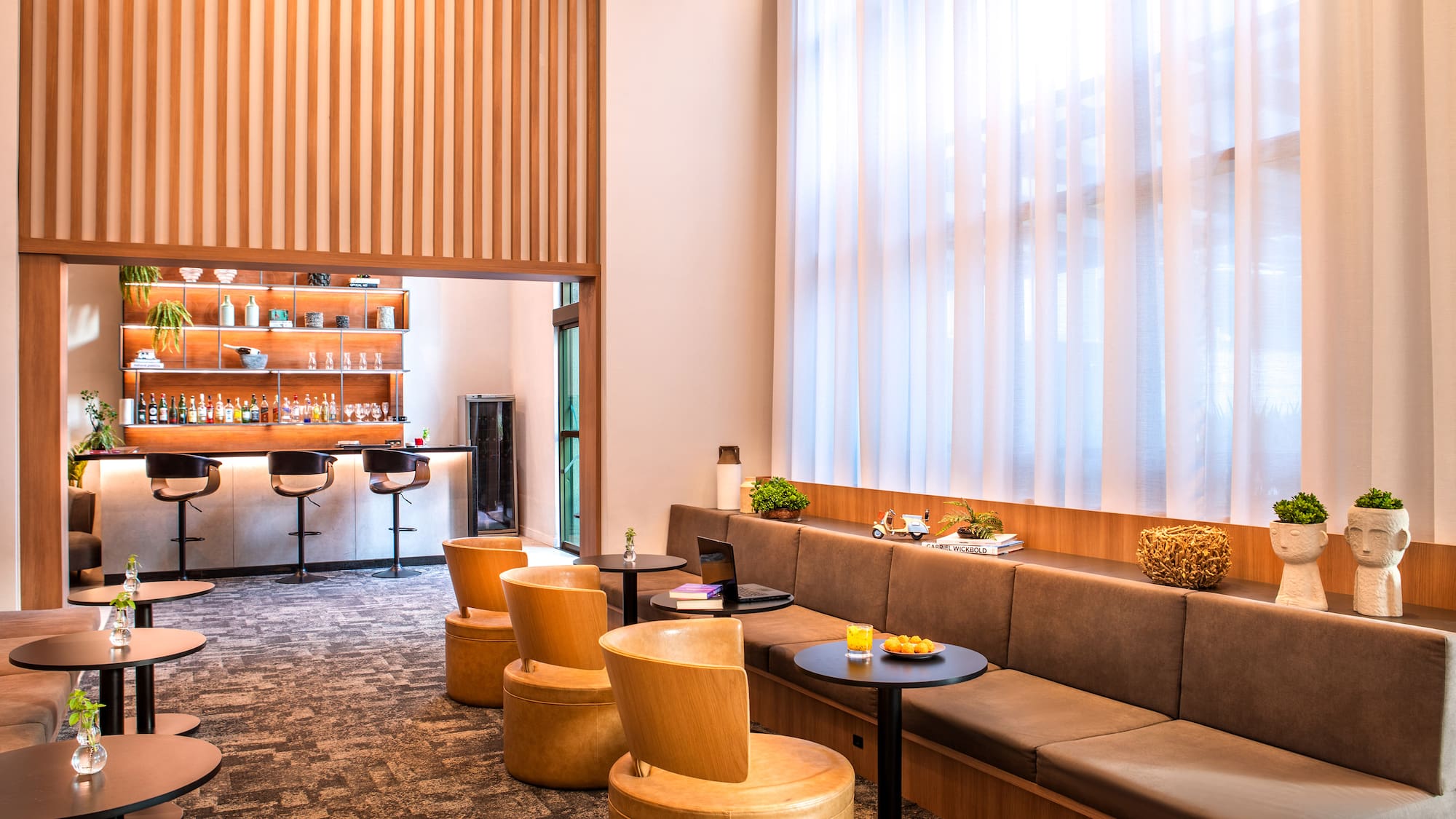 a room with a long couch and tables and chairs