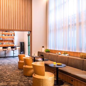 a room with a long couch and tables and chairs