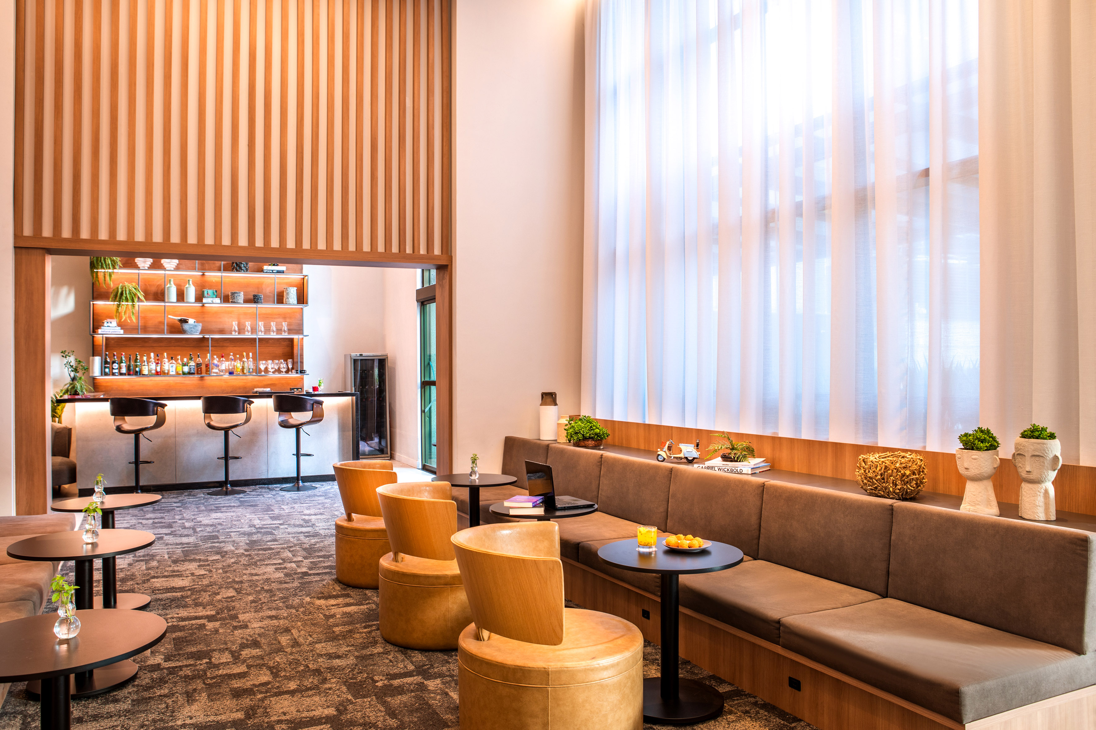 a room with a long couch and tables and chairs