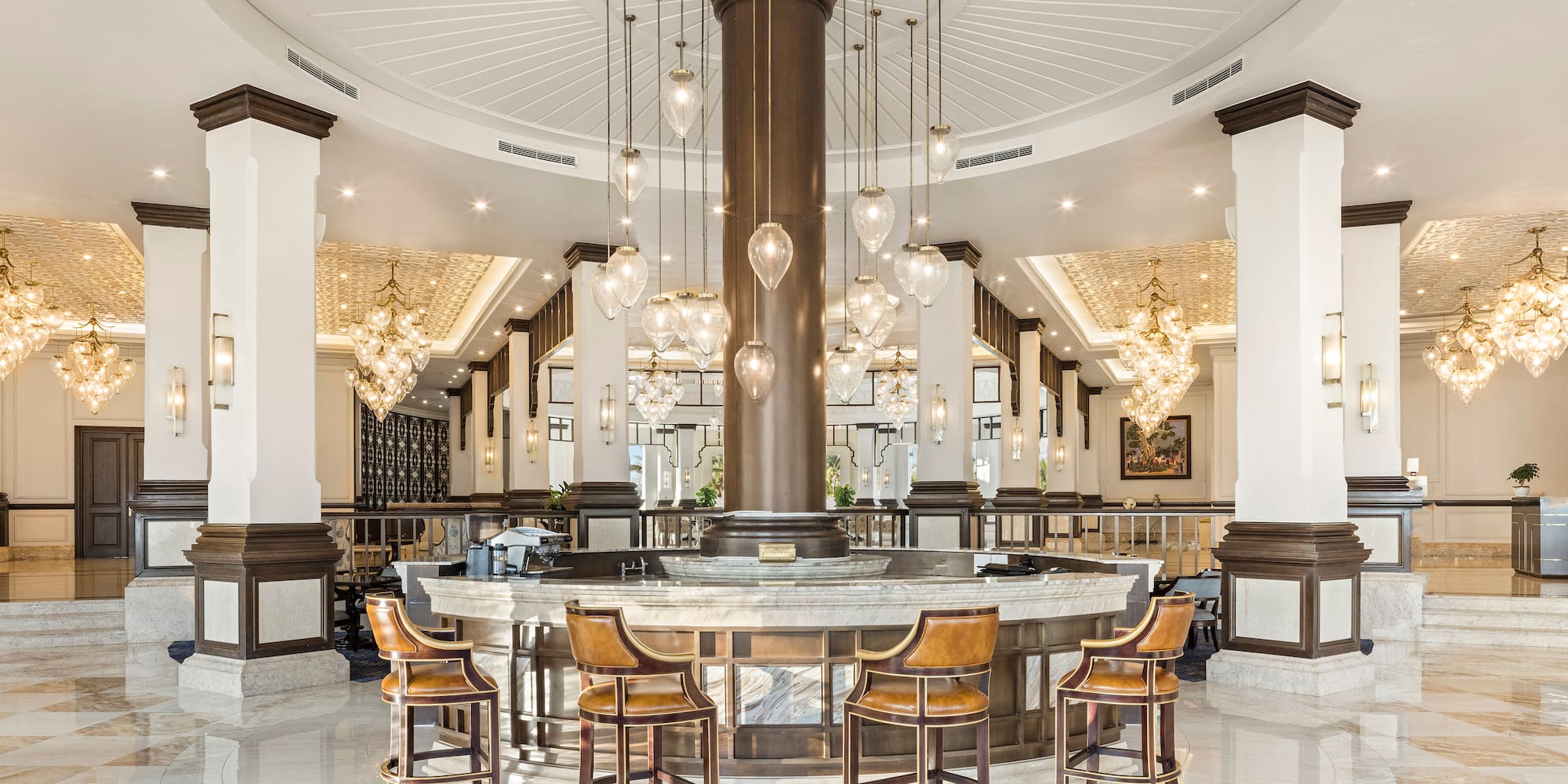 a large round table with chairs and chandeliers in a room