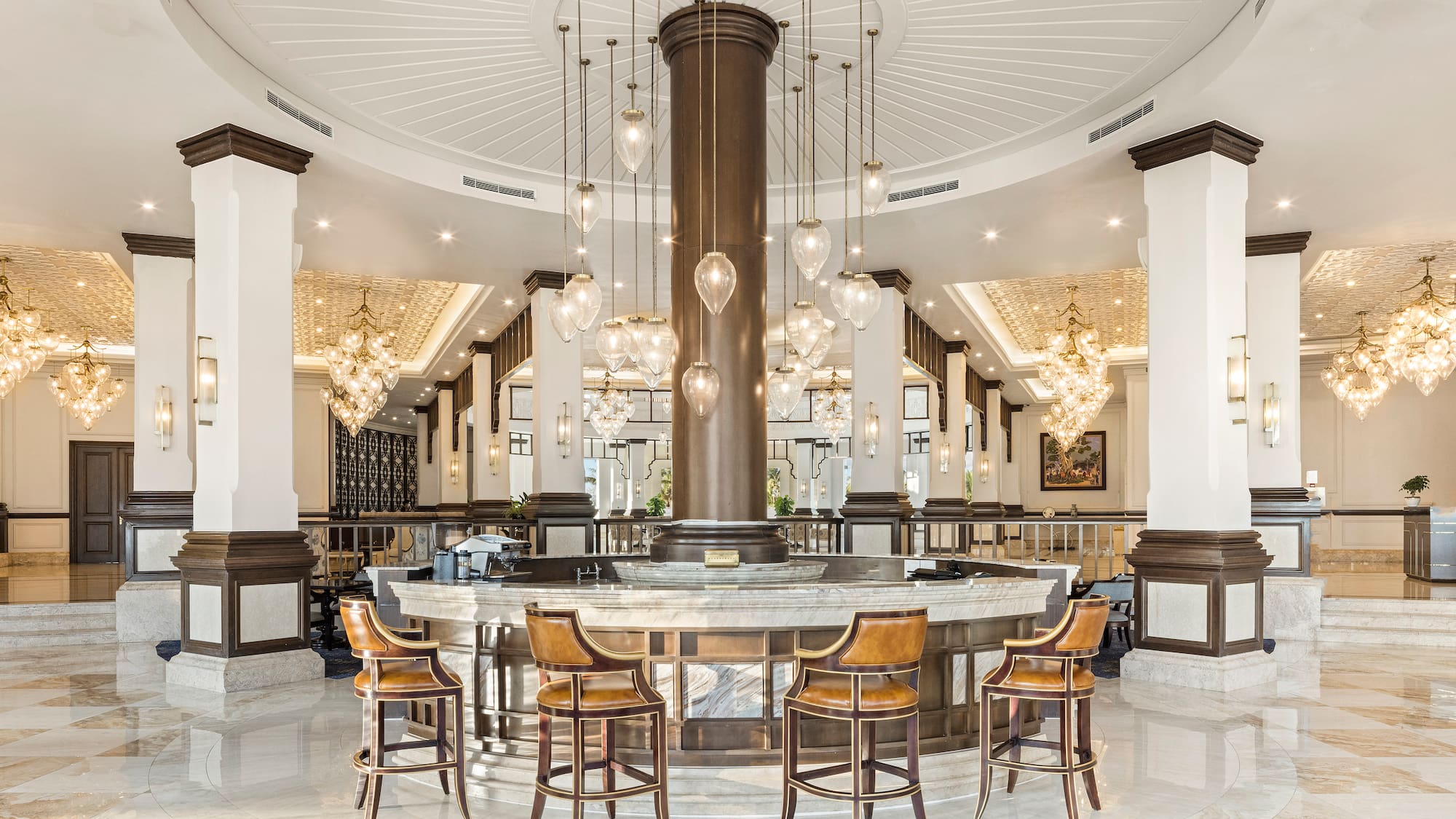 a large round table with chairs and chandeliers in a room