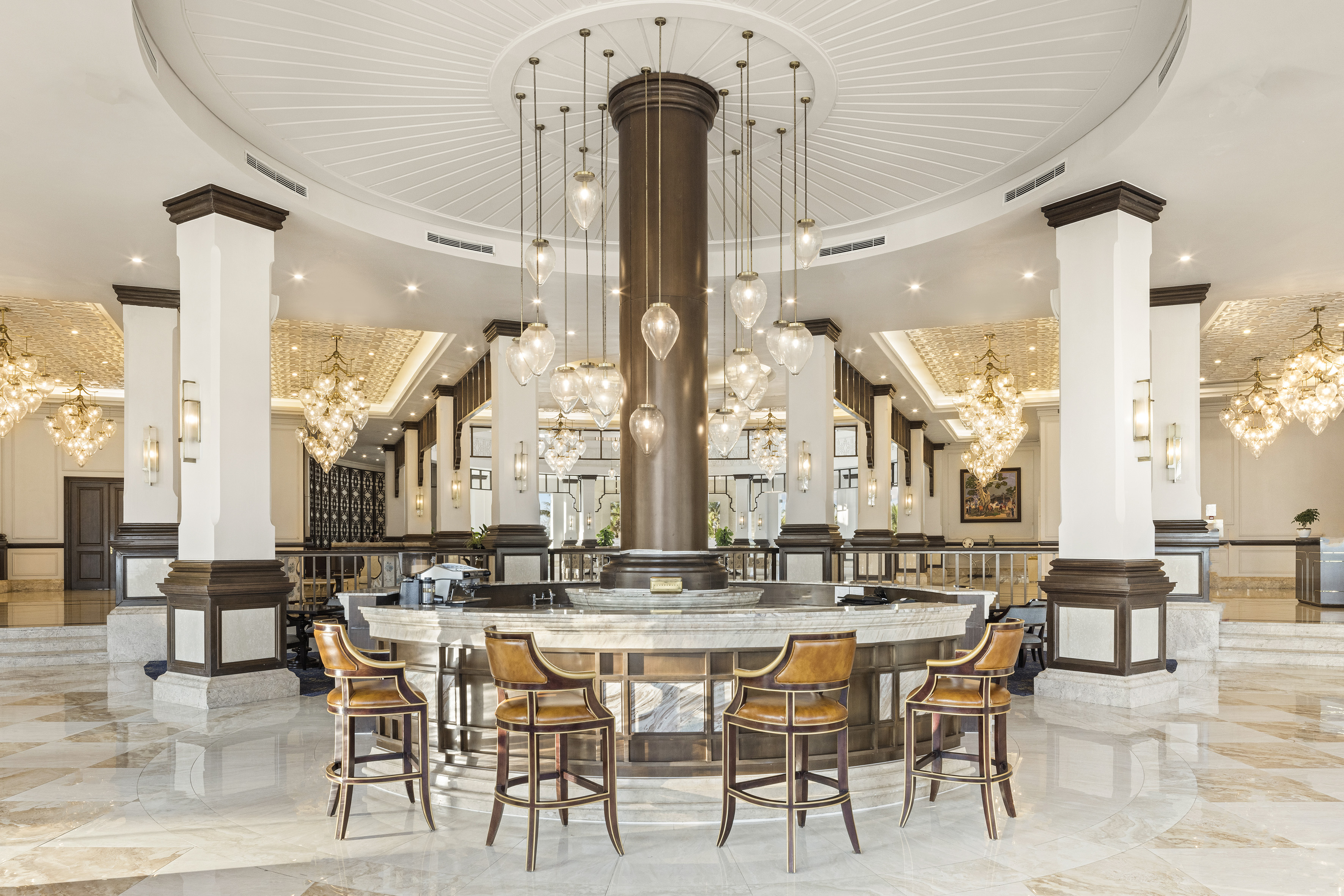 a large round table with chairs and chandeliers in a room