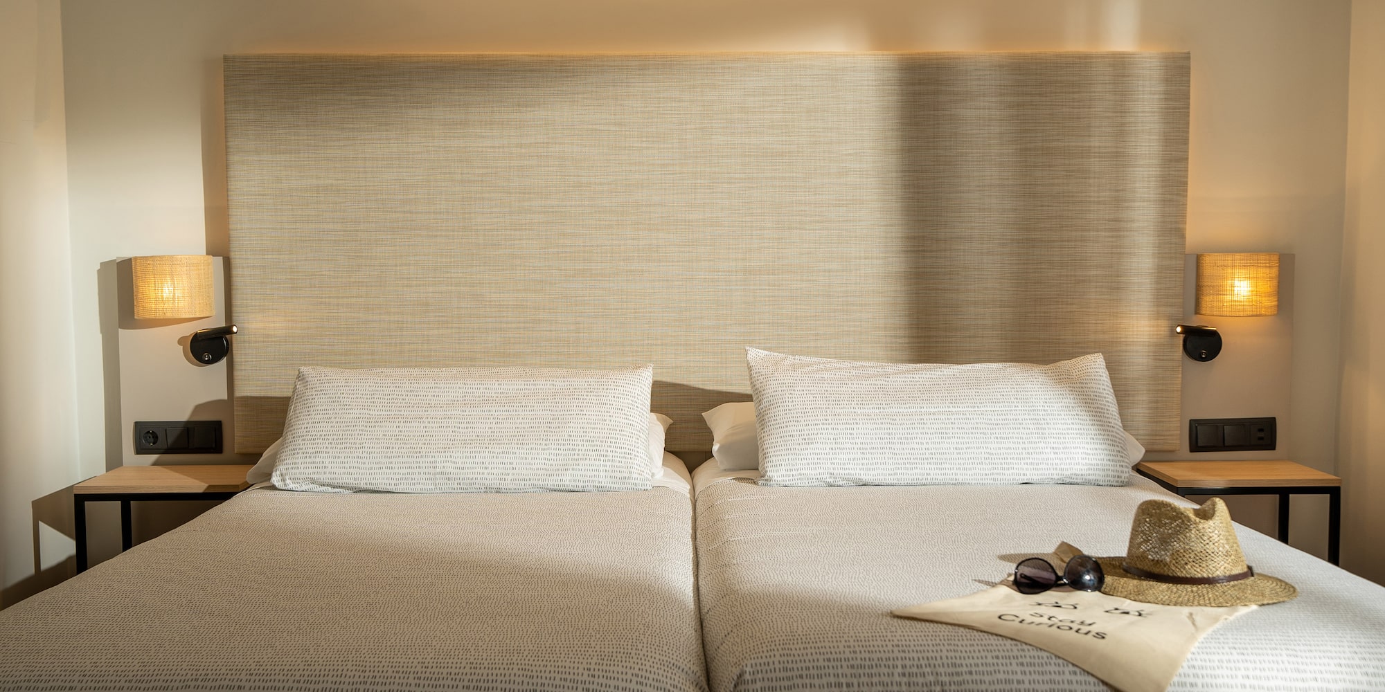 a pair of beds with a pair of sunglasses and a hat on top of it