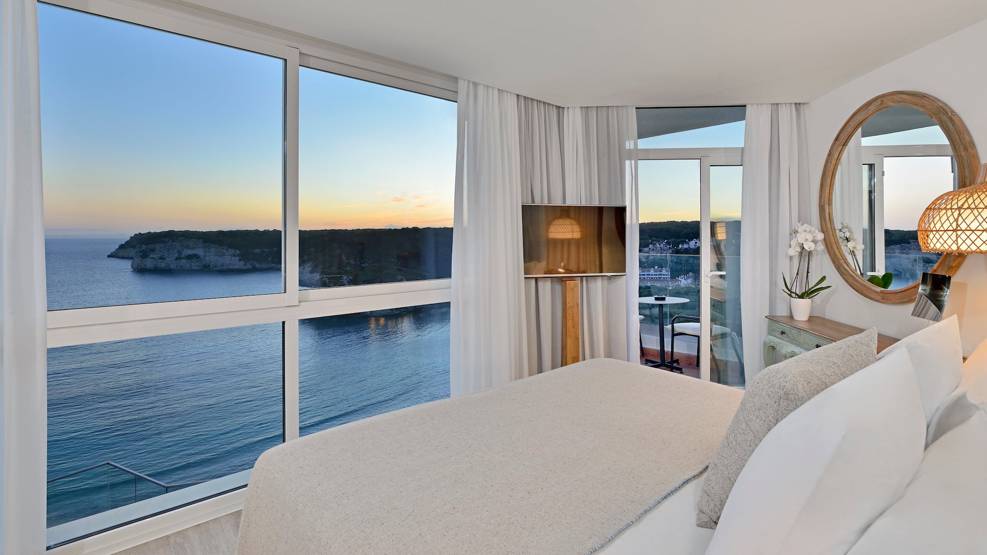 a bedroom with a view of the ocean and a window