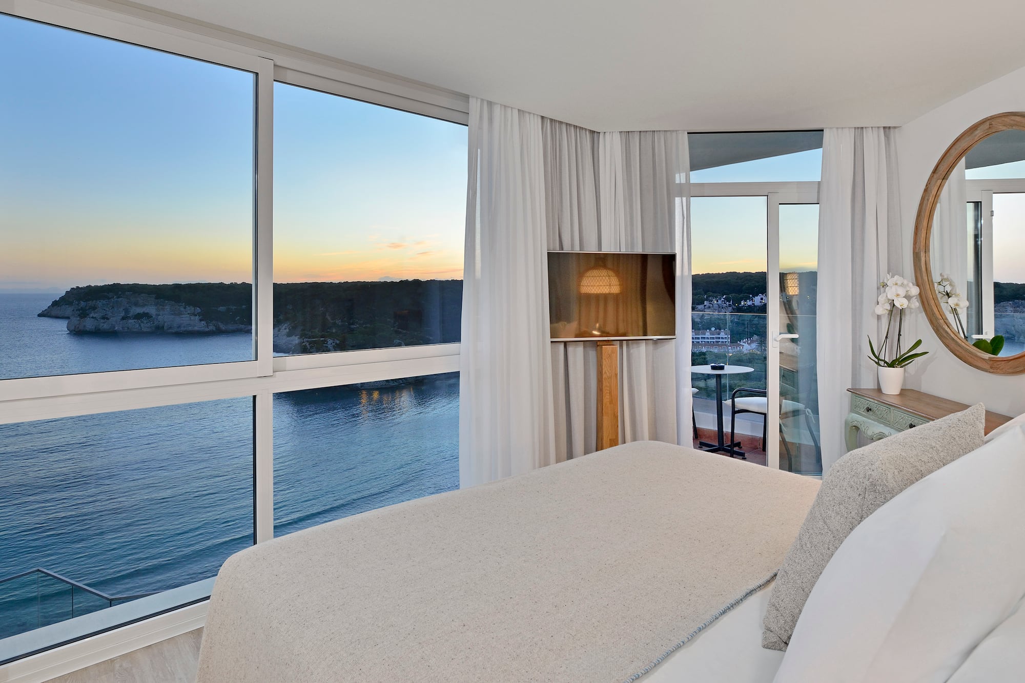 a bedroom with a view of the ocean and a window