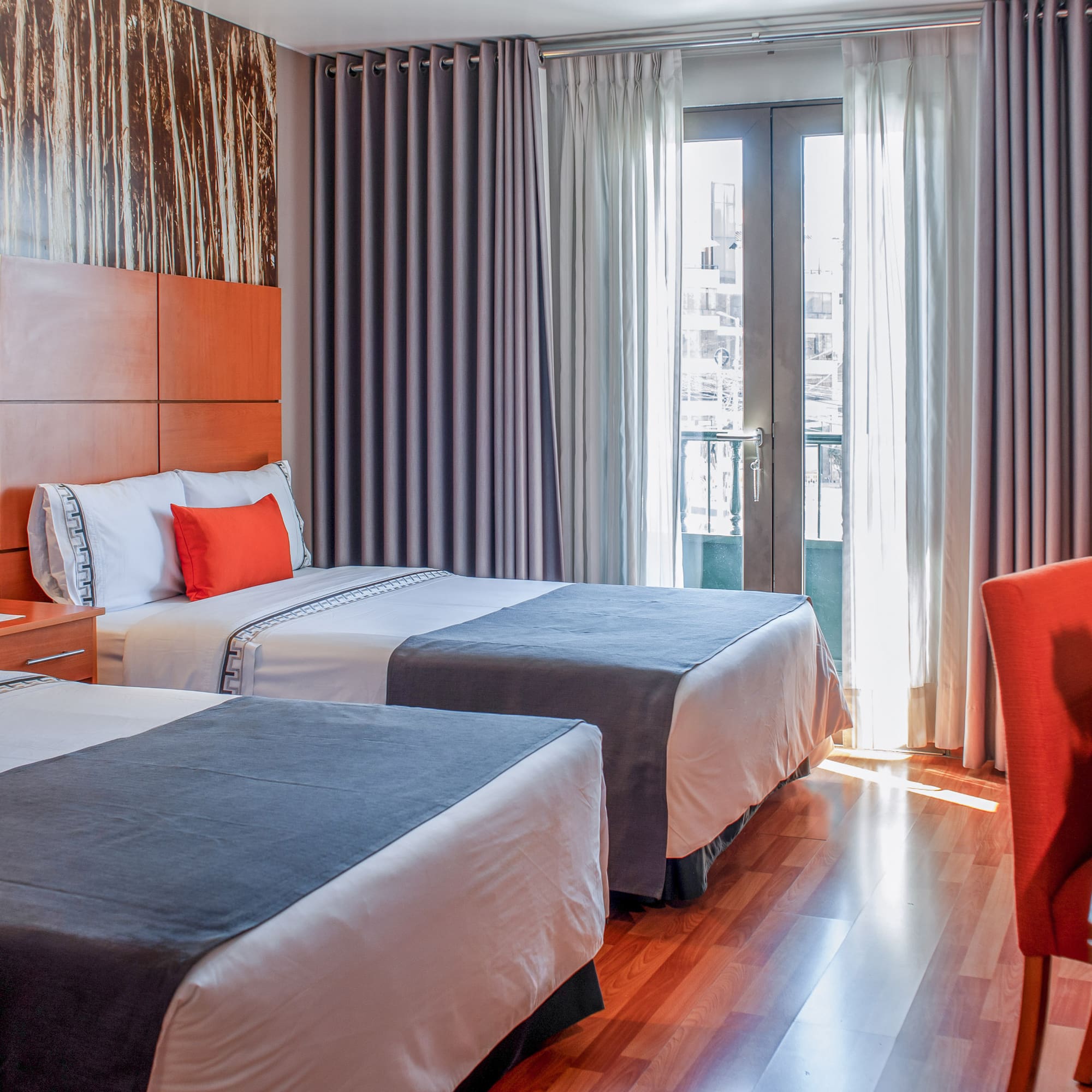 a room with two beds and a red chair