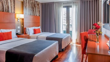 a room with two beds and a red chair