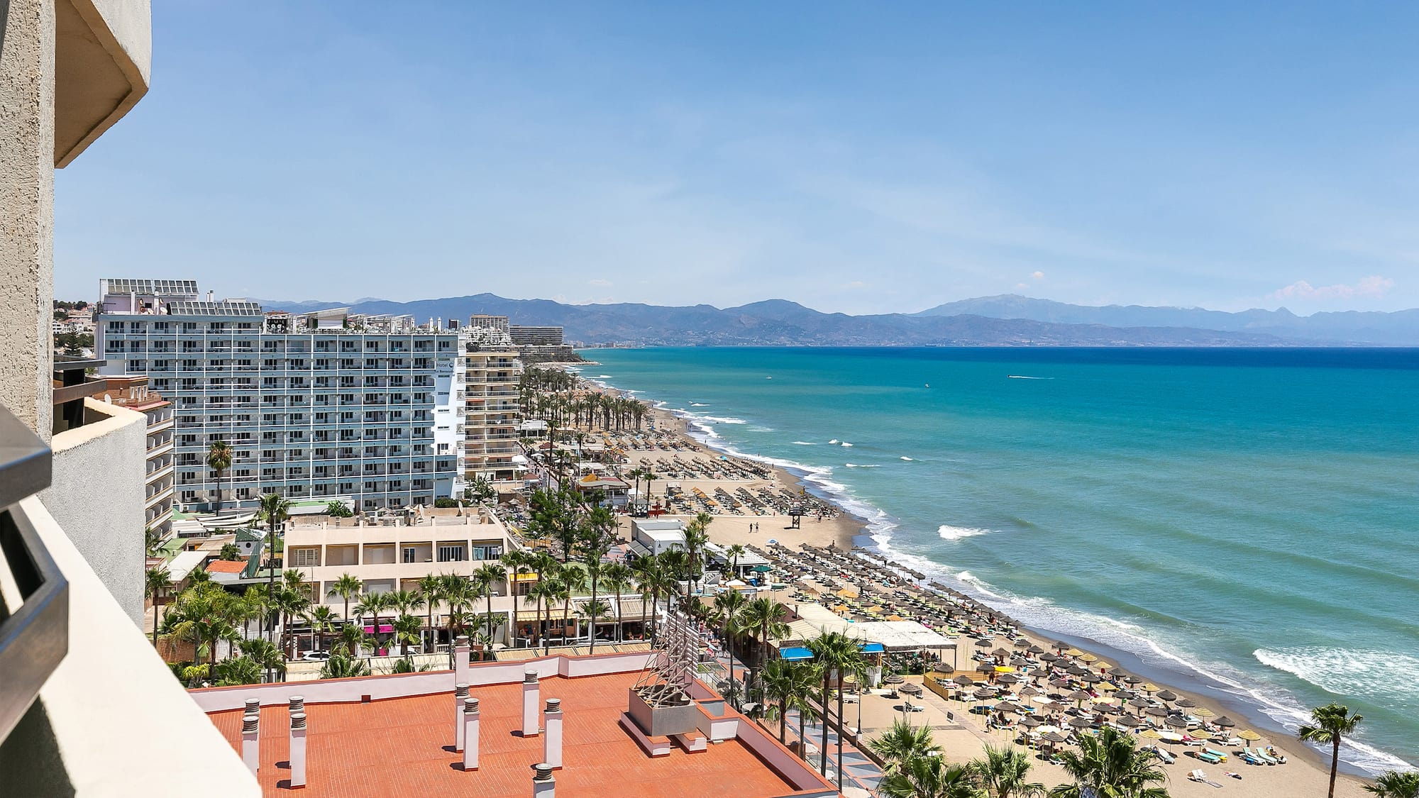 a beach with buildings and palm trees