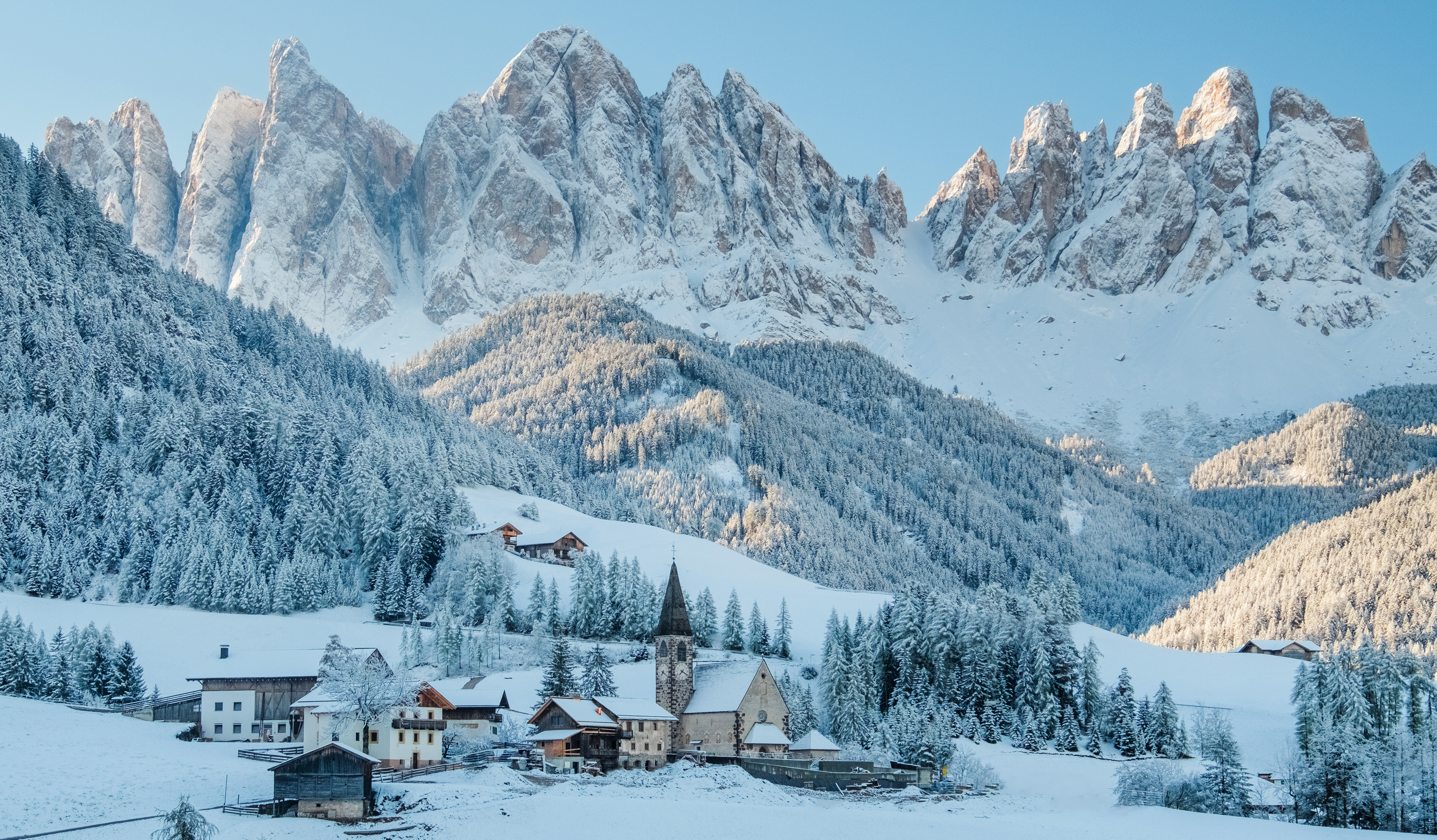 a snowy mountain with a village in the background