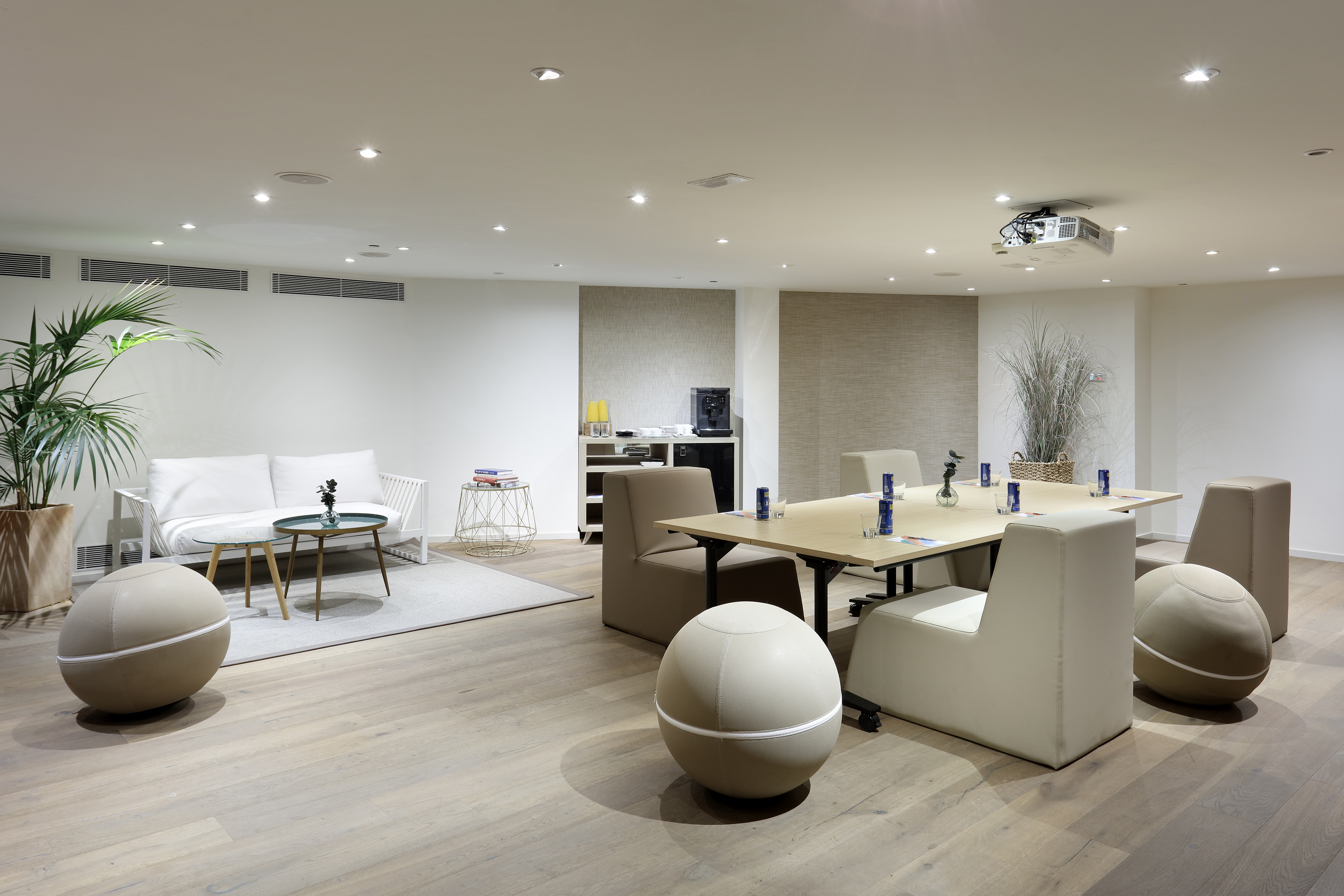 Business meeting room with conference table, lounge seating, ceiling projector.