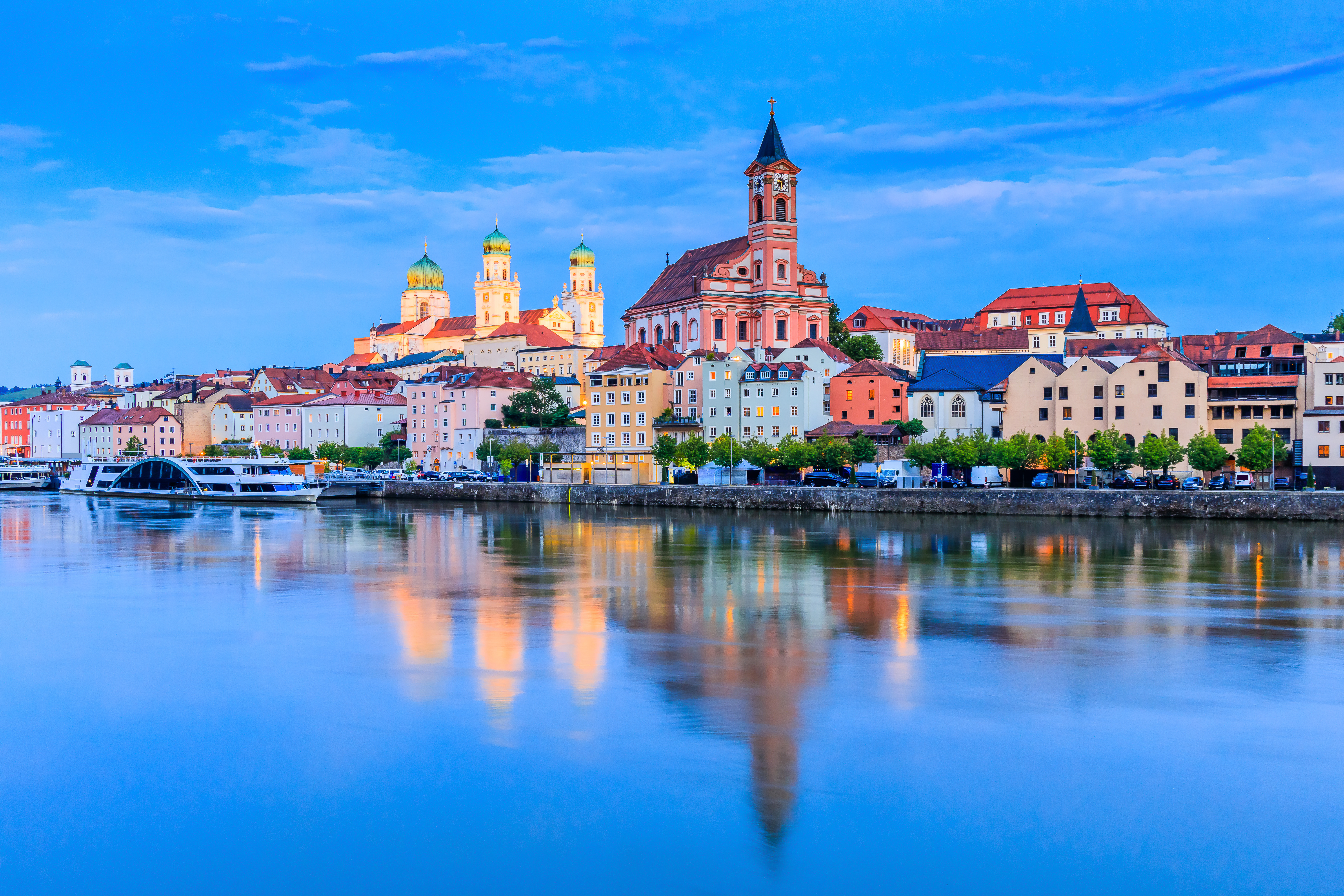 Passau, Alemania: edificios coloridos, catedral y río Danubio al atardecer.