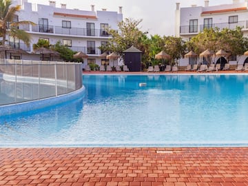 a pool with a fence and a building in the background