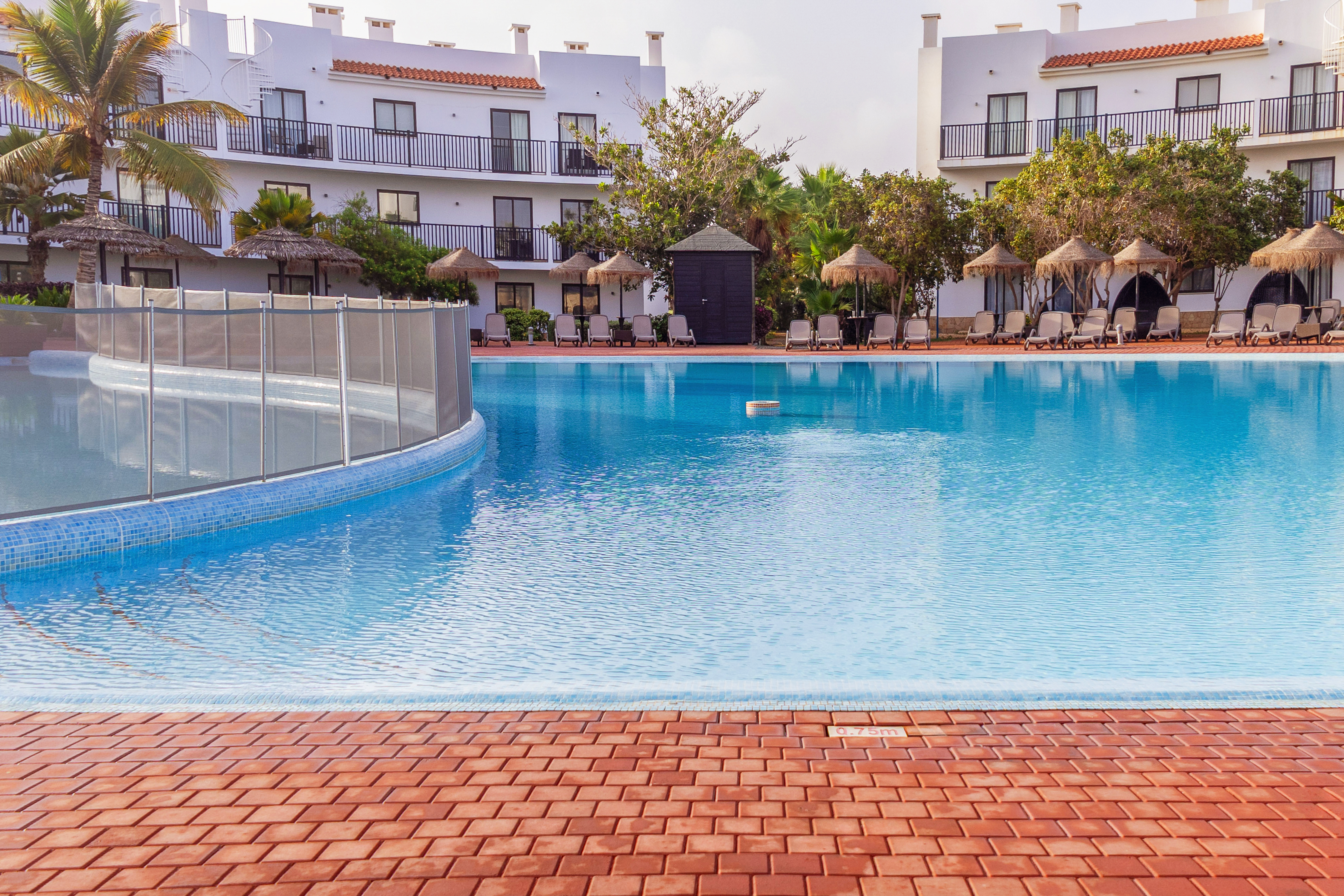 a pool with a fence and a building in the background