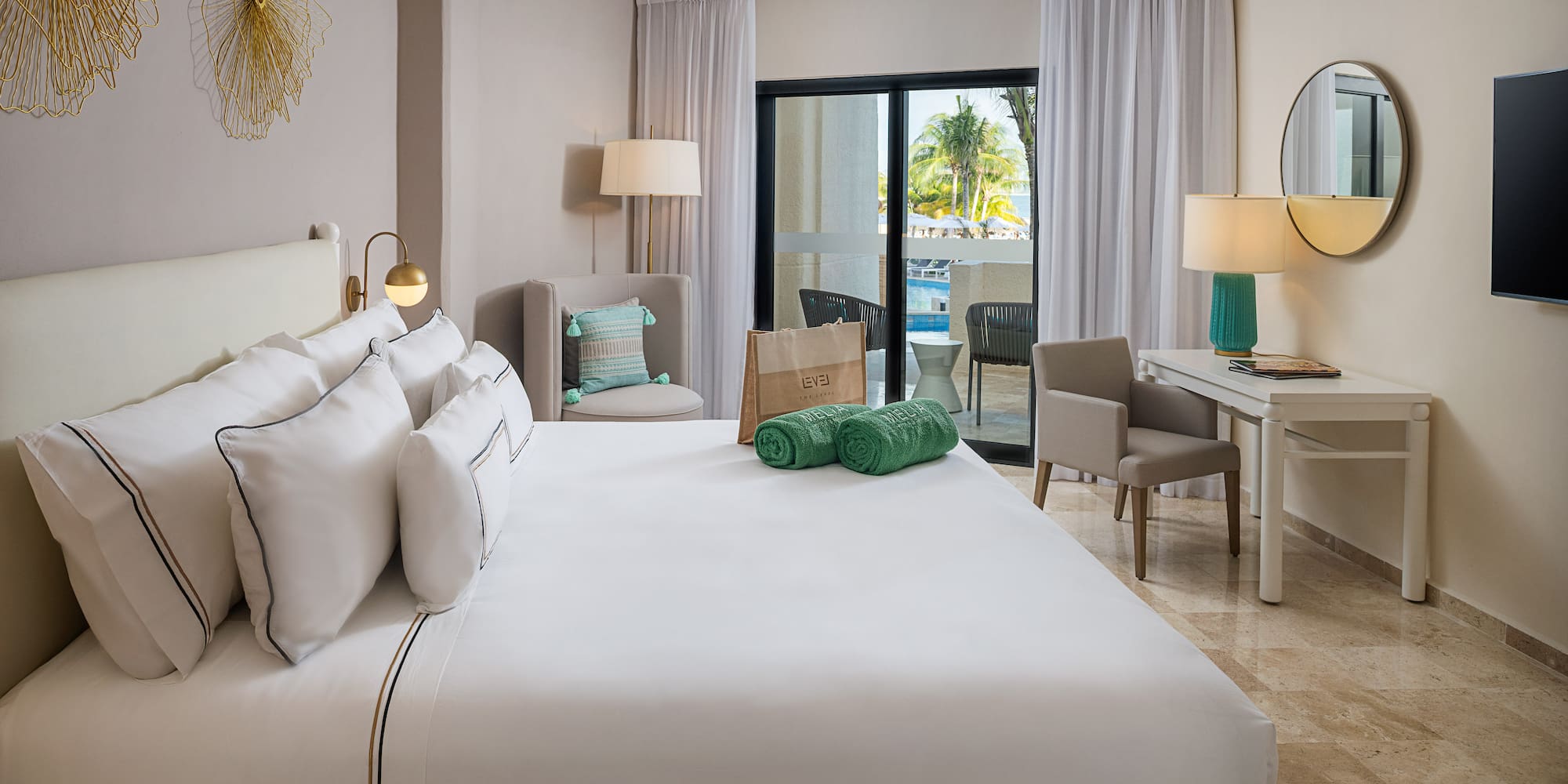 a bedroom with a large bed and a desk and chairs