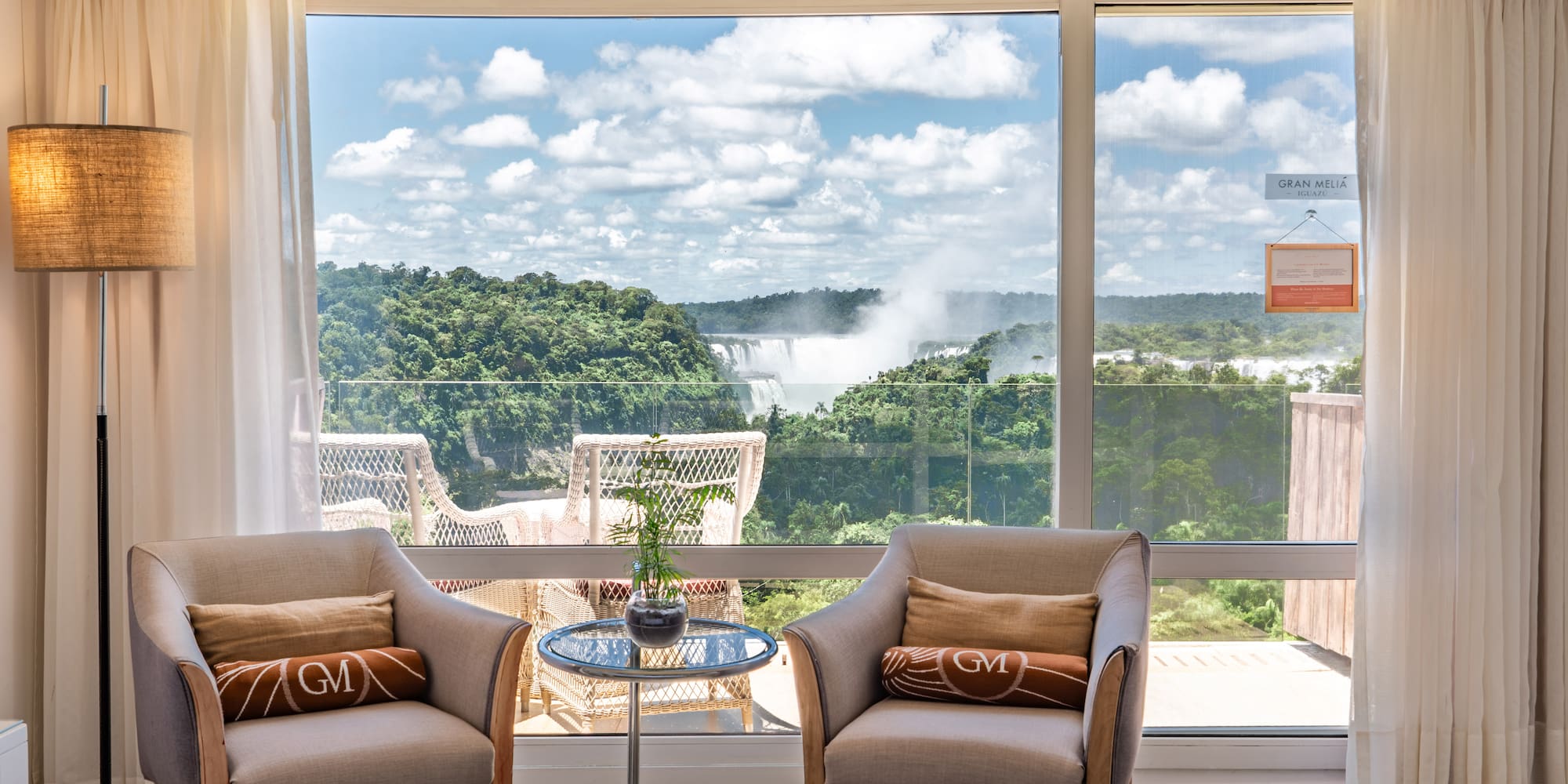 a room with a view of a waterfall and a bed