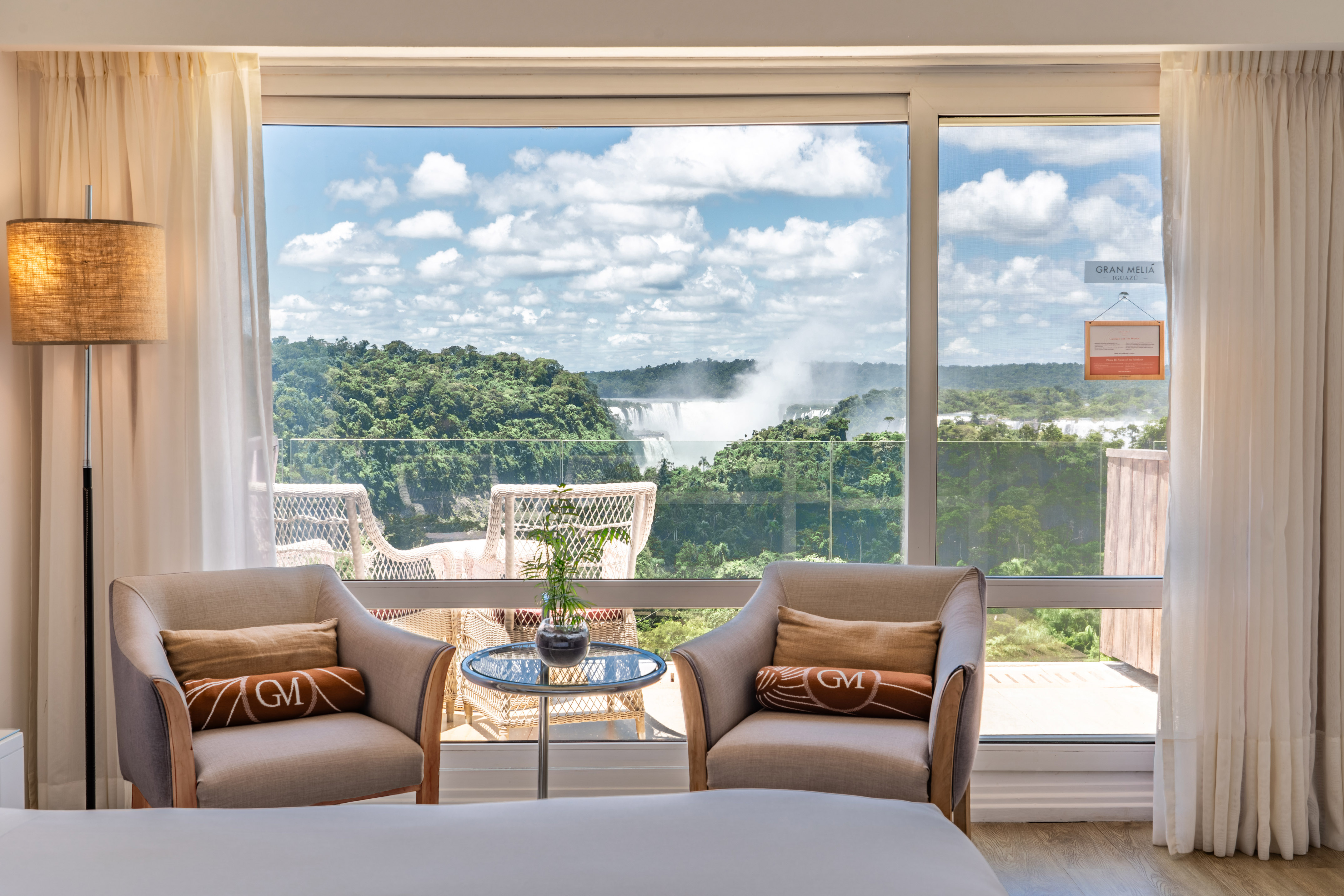 a room with a view of a waterfall and a bed