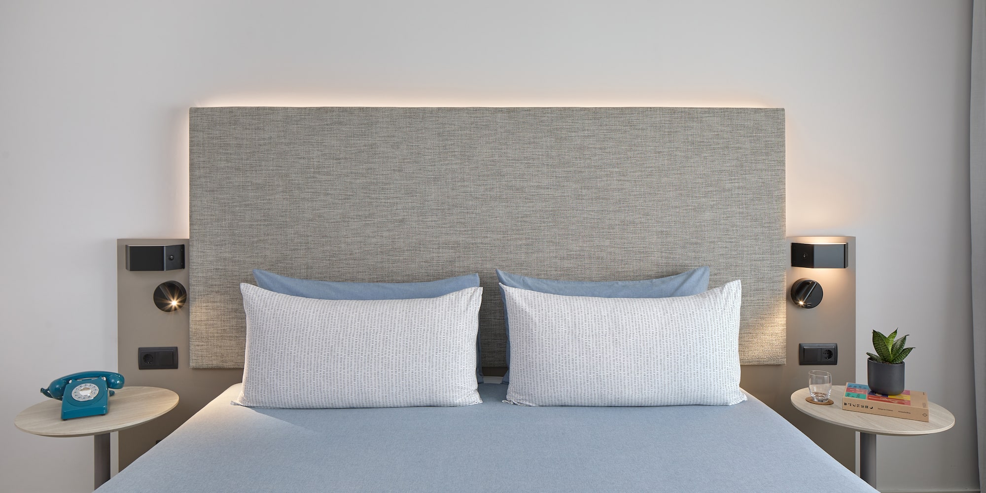 a bed with a headboard and a lamp