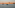 Valletta, Malta cityscape at sunset with historic buildings and boats in the harbor.