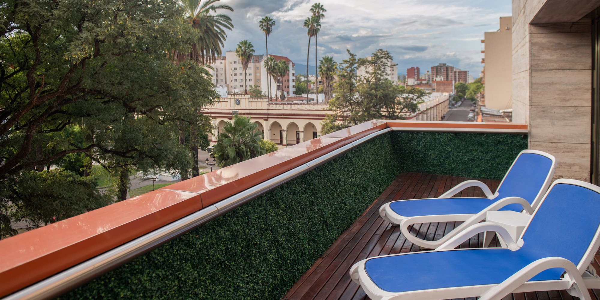 a deck with chairs on a balcony overlooking a city