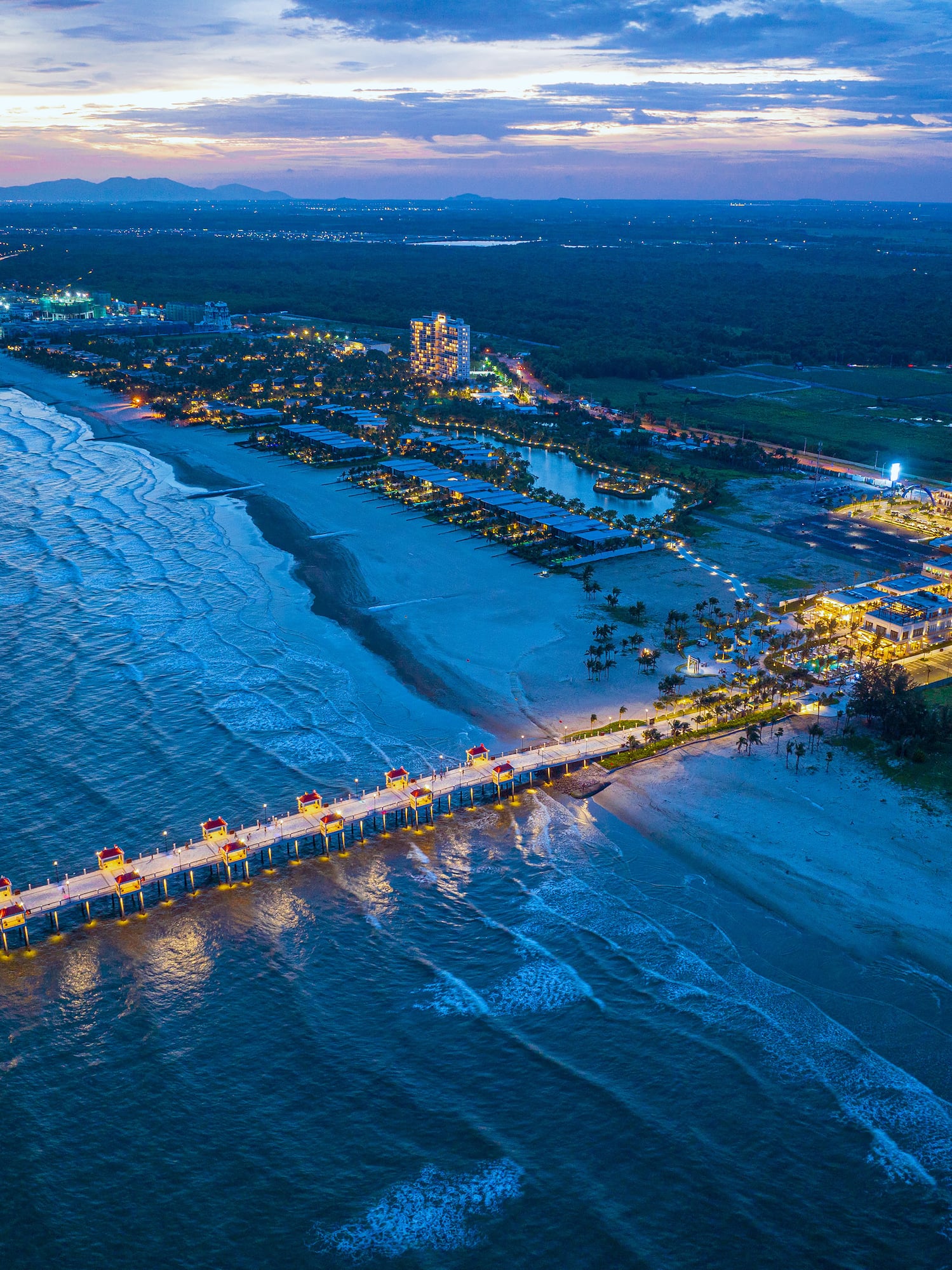a long pier with lights on it and a body of water