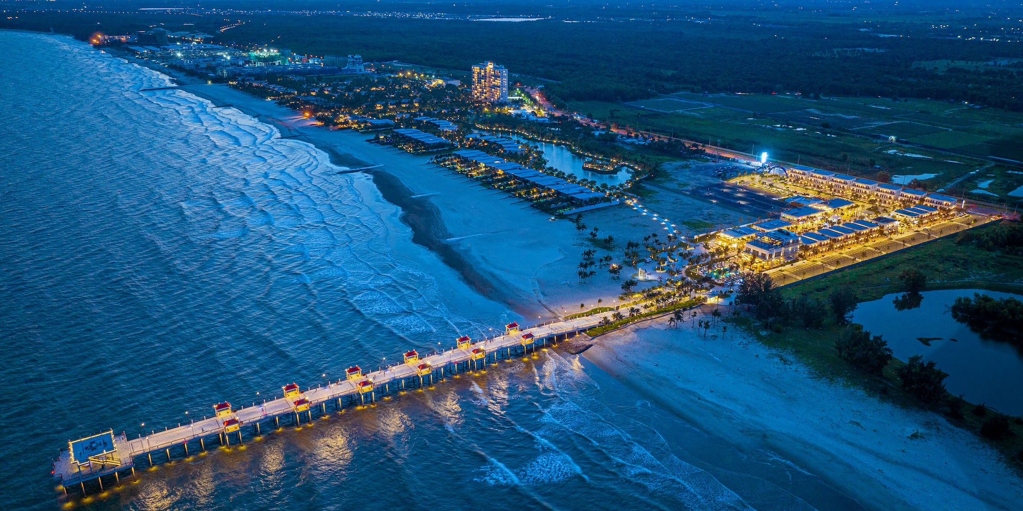 a long pier with lights on it and a body of water
