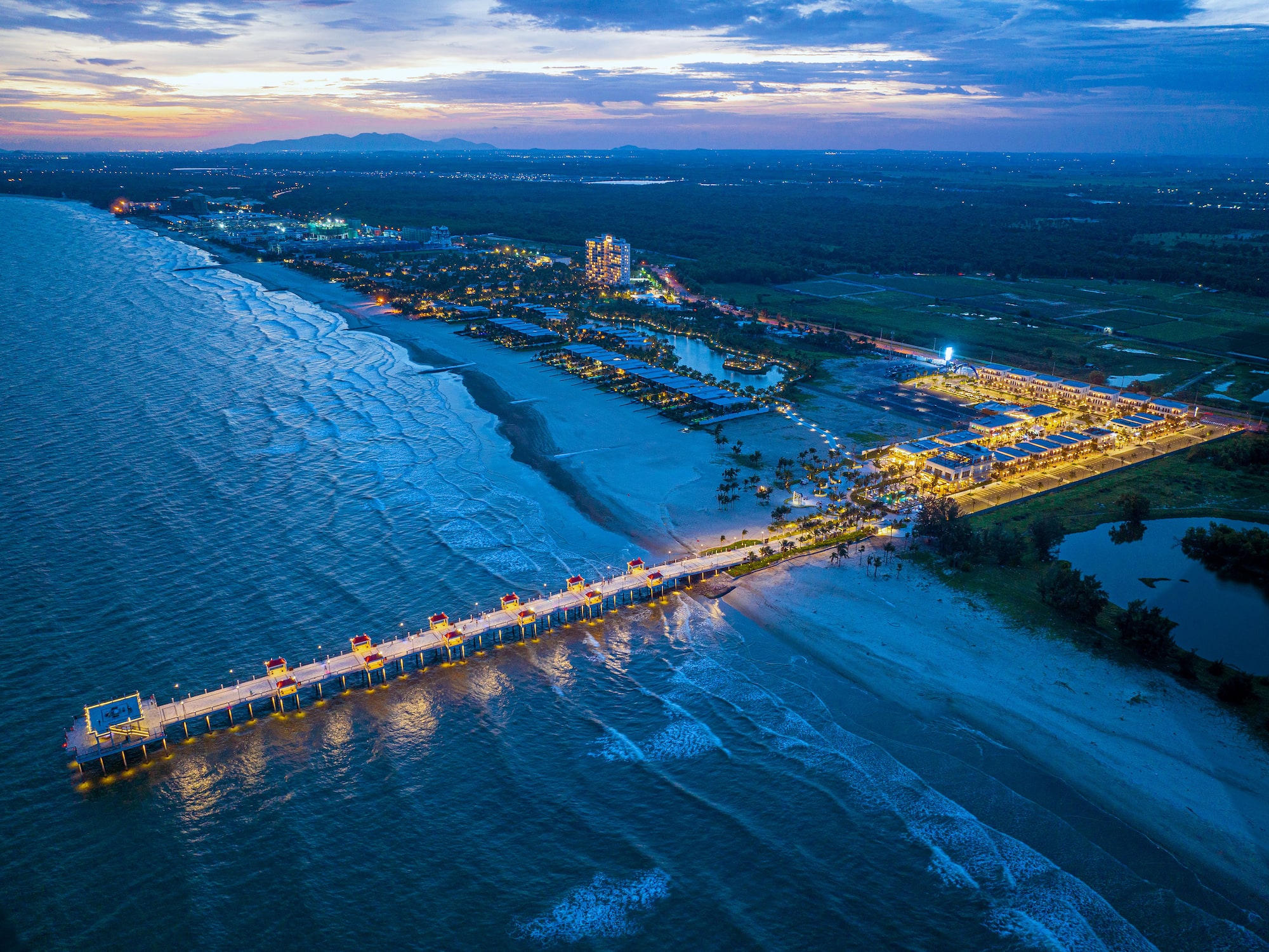 a long pier with lights on it and a body of water