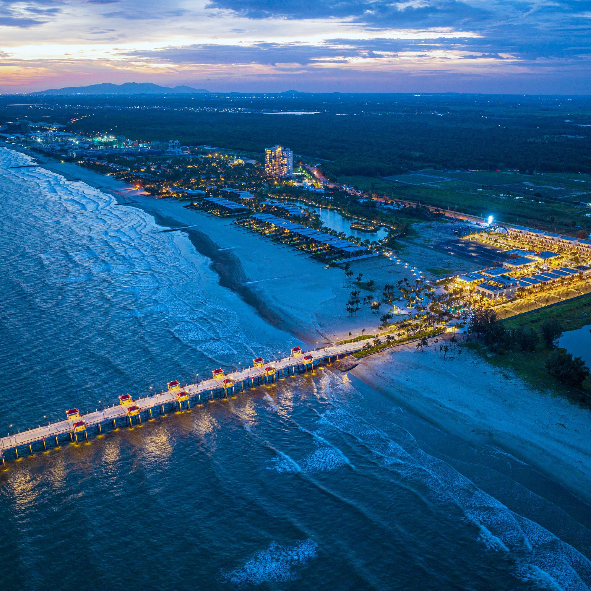 a long pier with lights on it and a body of water