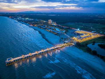 a long pier with lights on it and a body of water