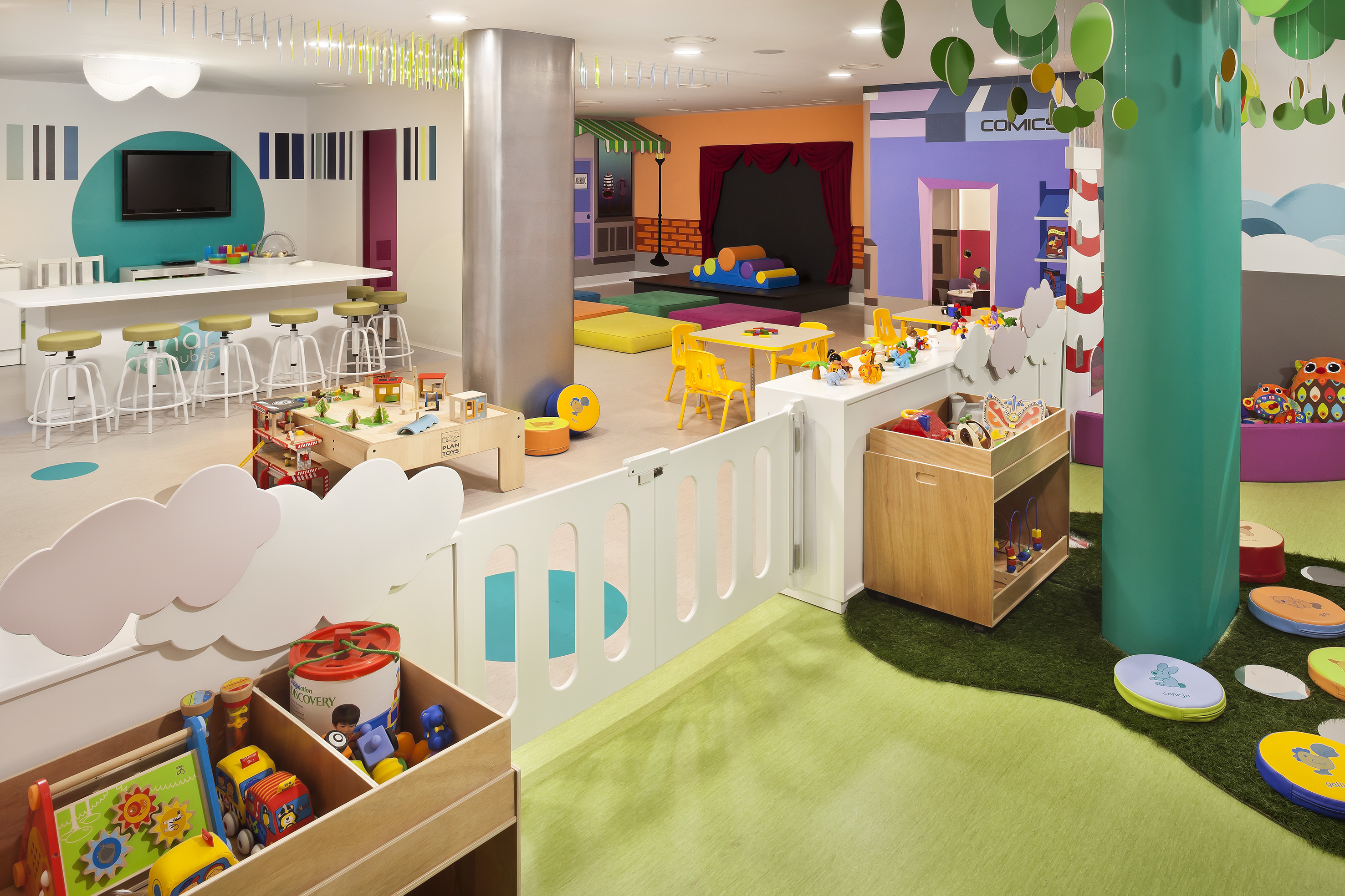 Colorful kids club with soft play, toys, activity tables, and stage.