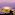 Illuminated coastal resort at twilight with palm trees and ocean view.