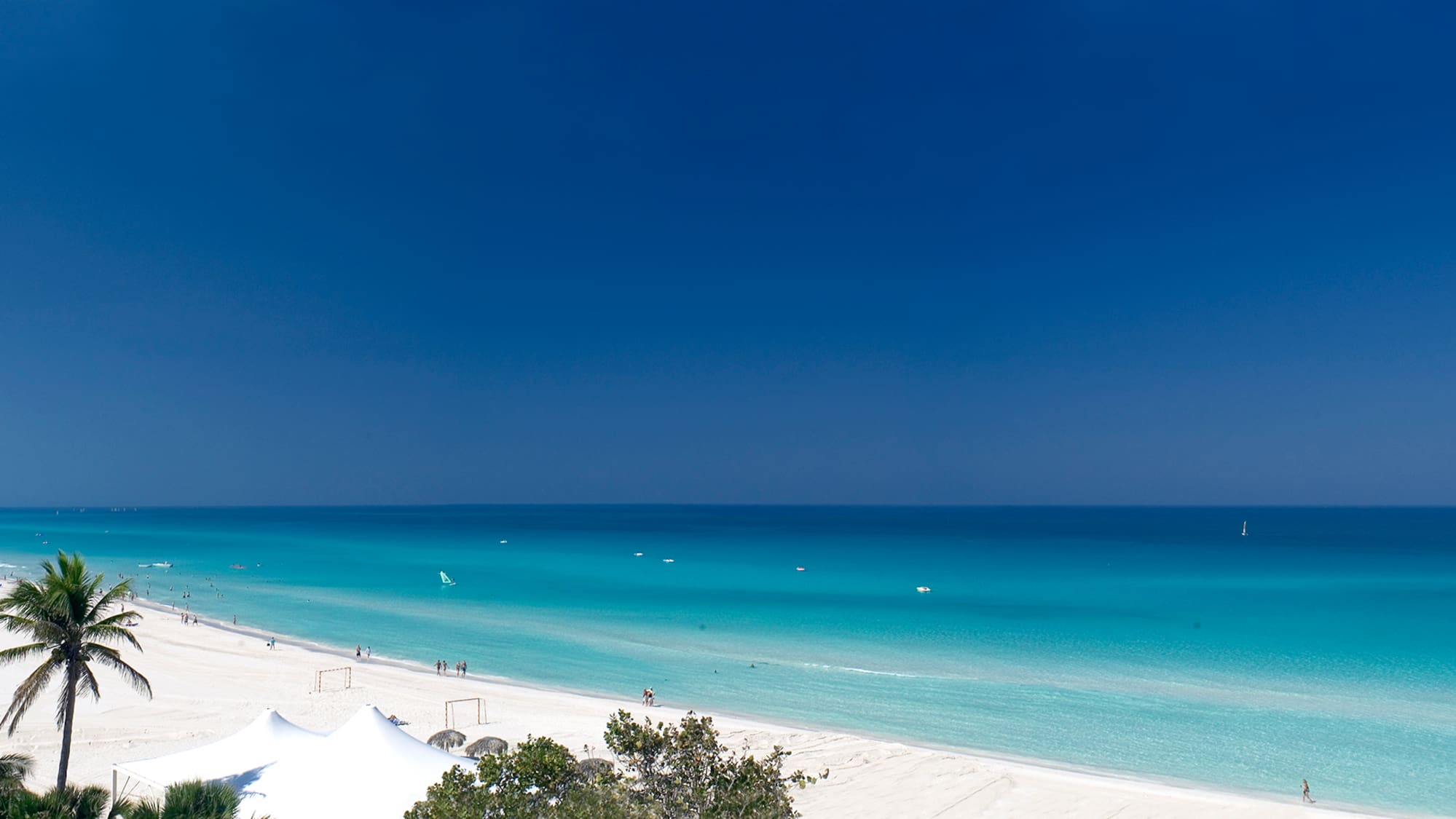 a beach with white sand and blue water