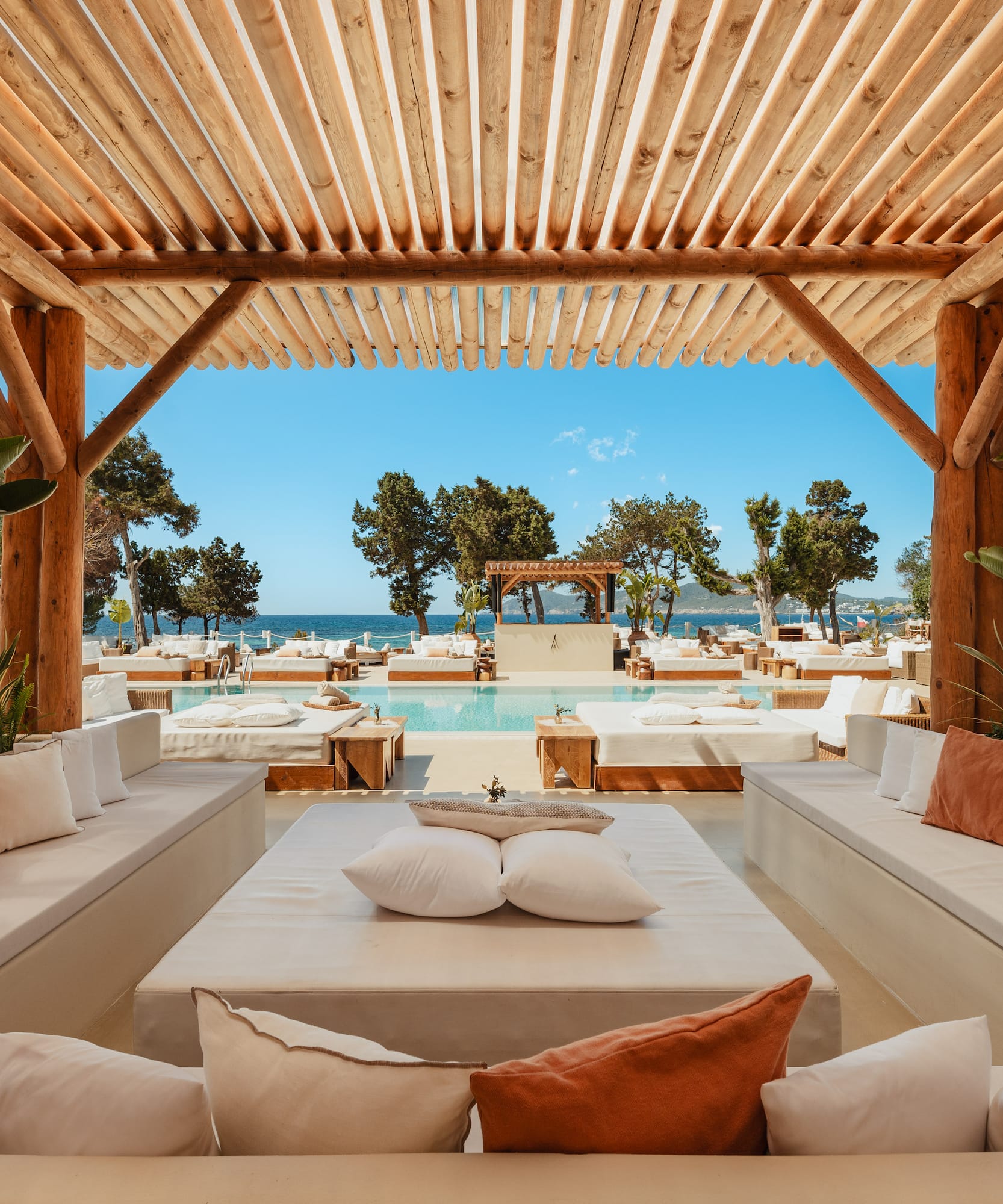a pool with a wooden structure and white couches