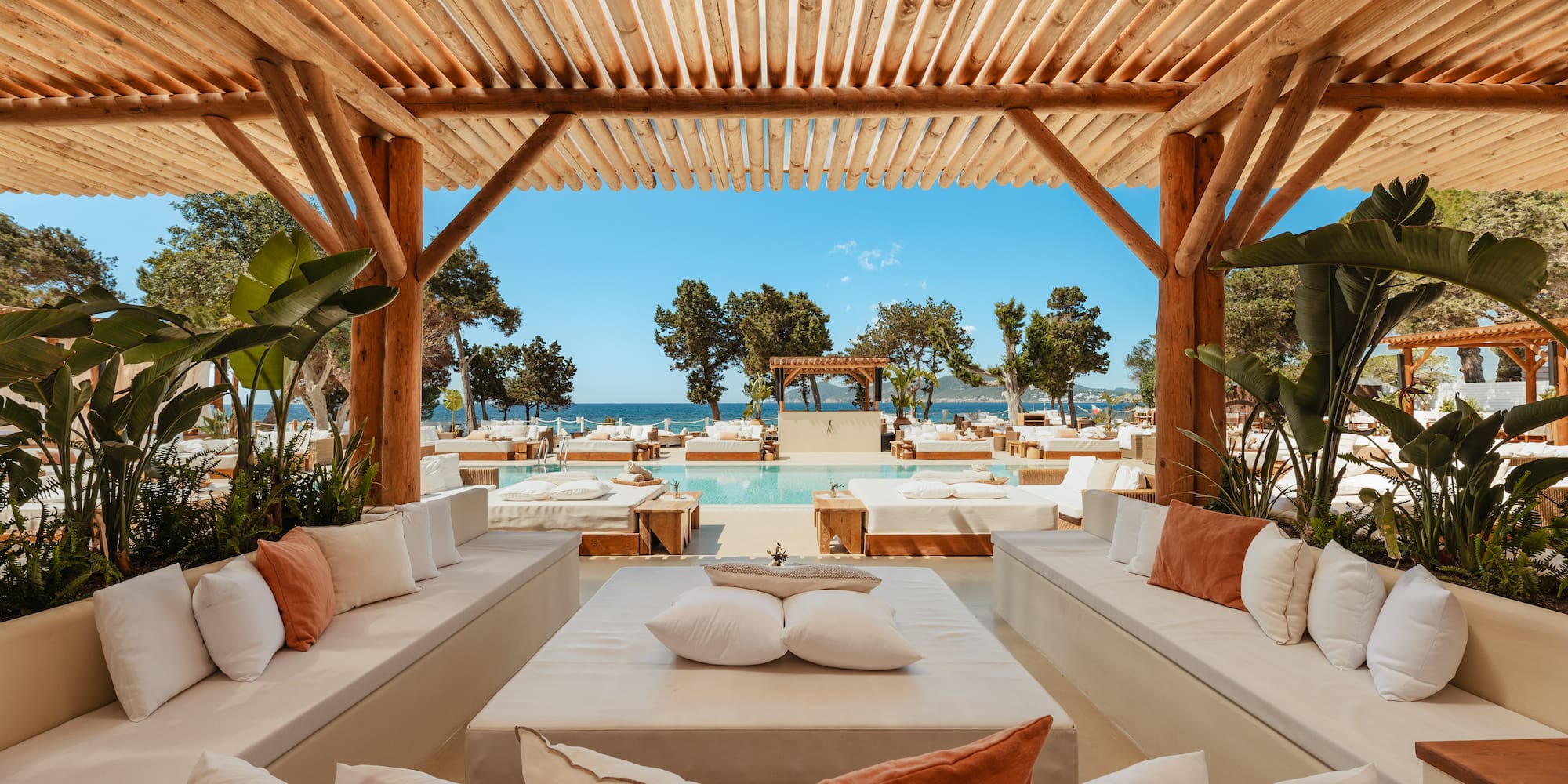 a pool with a wooden structure and white couches