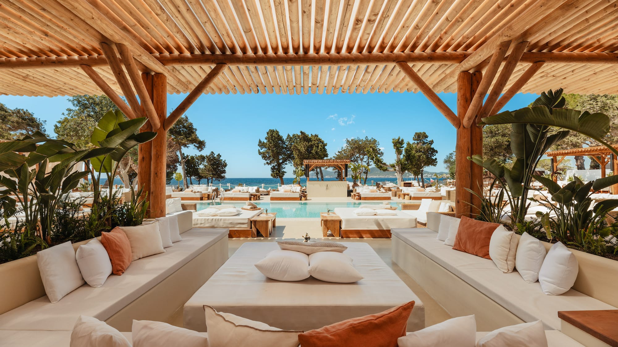 a pool with a wooden structure and white couches