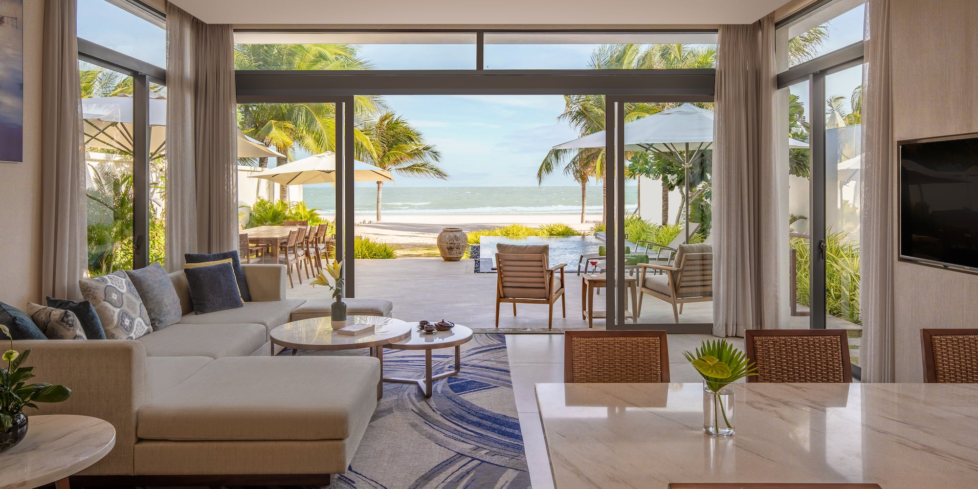 a living room with a large glass door and a large couch