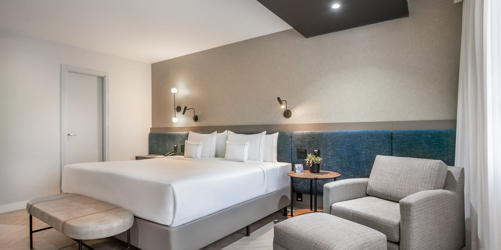 a room with a bed and chairs