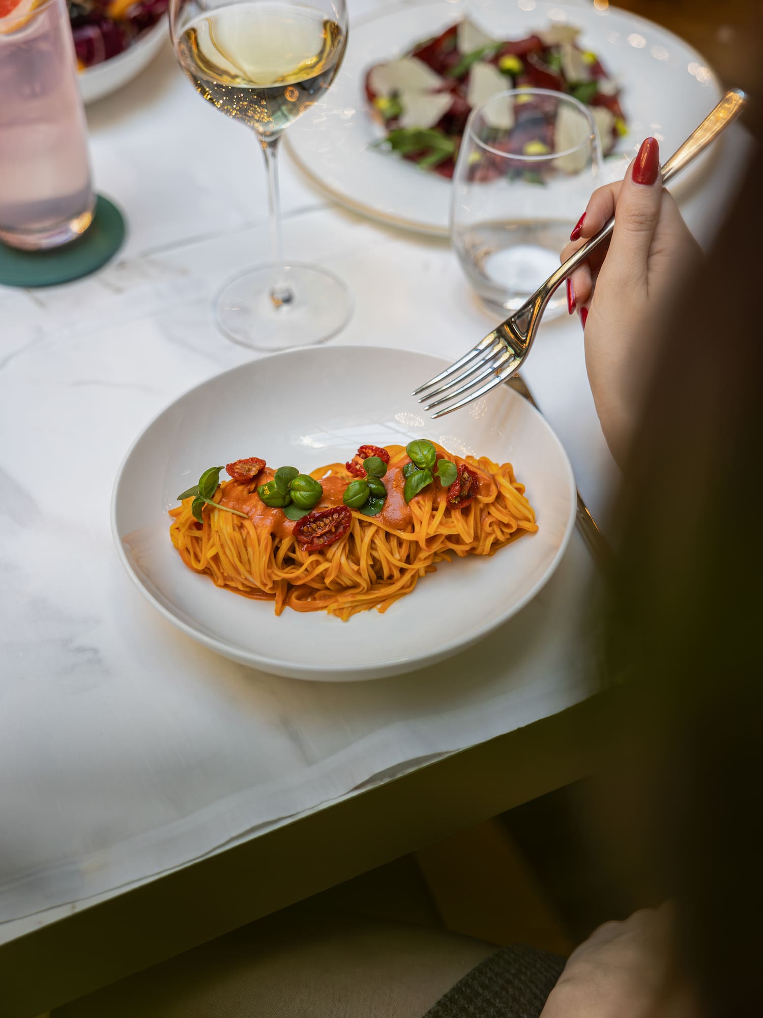 a plate of pasta with vegetables and a fork