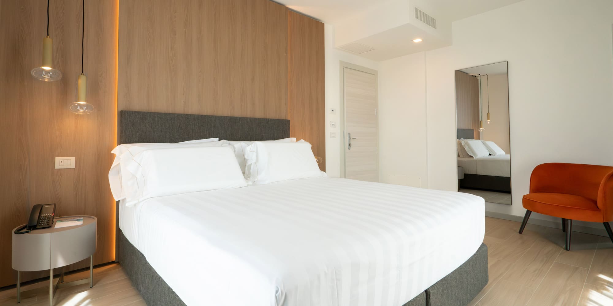 a bed with white sheets and a wood paneled wall