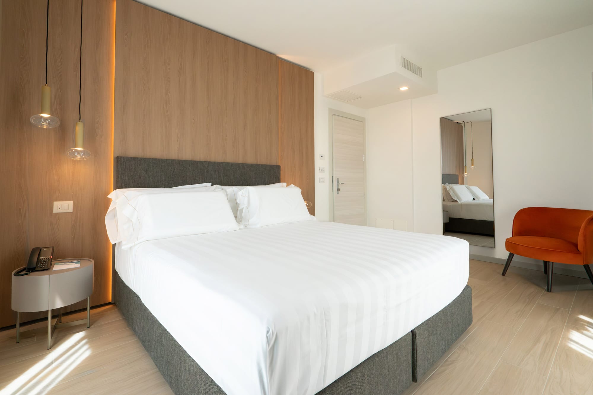 a bed with white sheets and a wood paneled wall