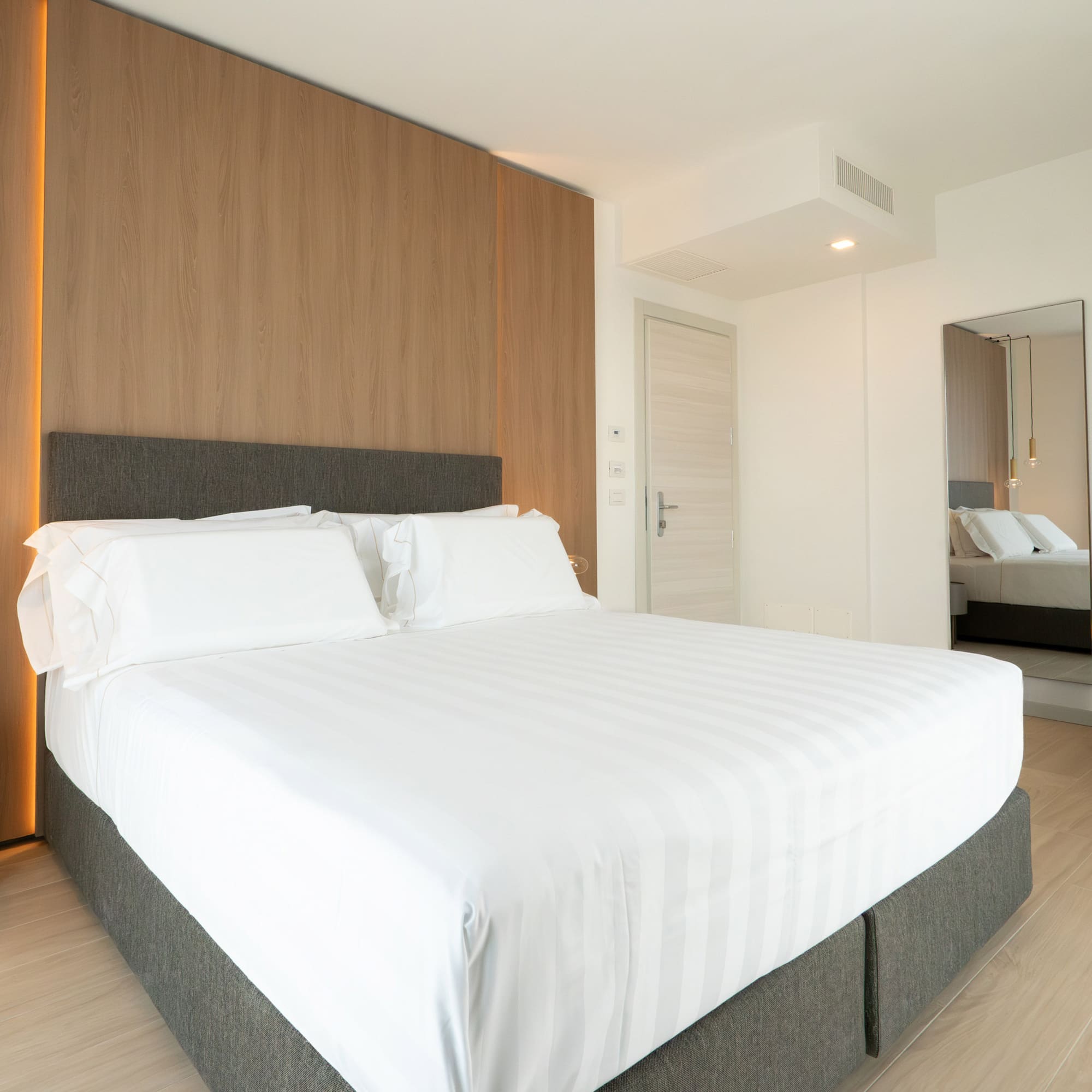 a bed with white sheets and a wood paneled wall