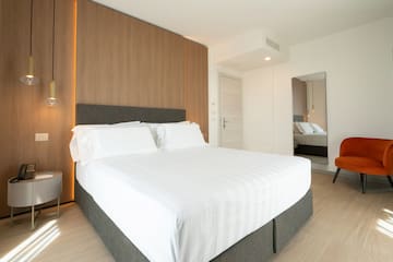 a bed with white sheets and a wood paneled wall