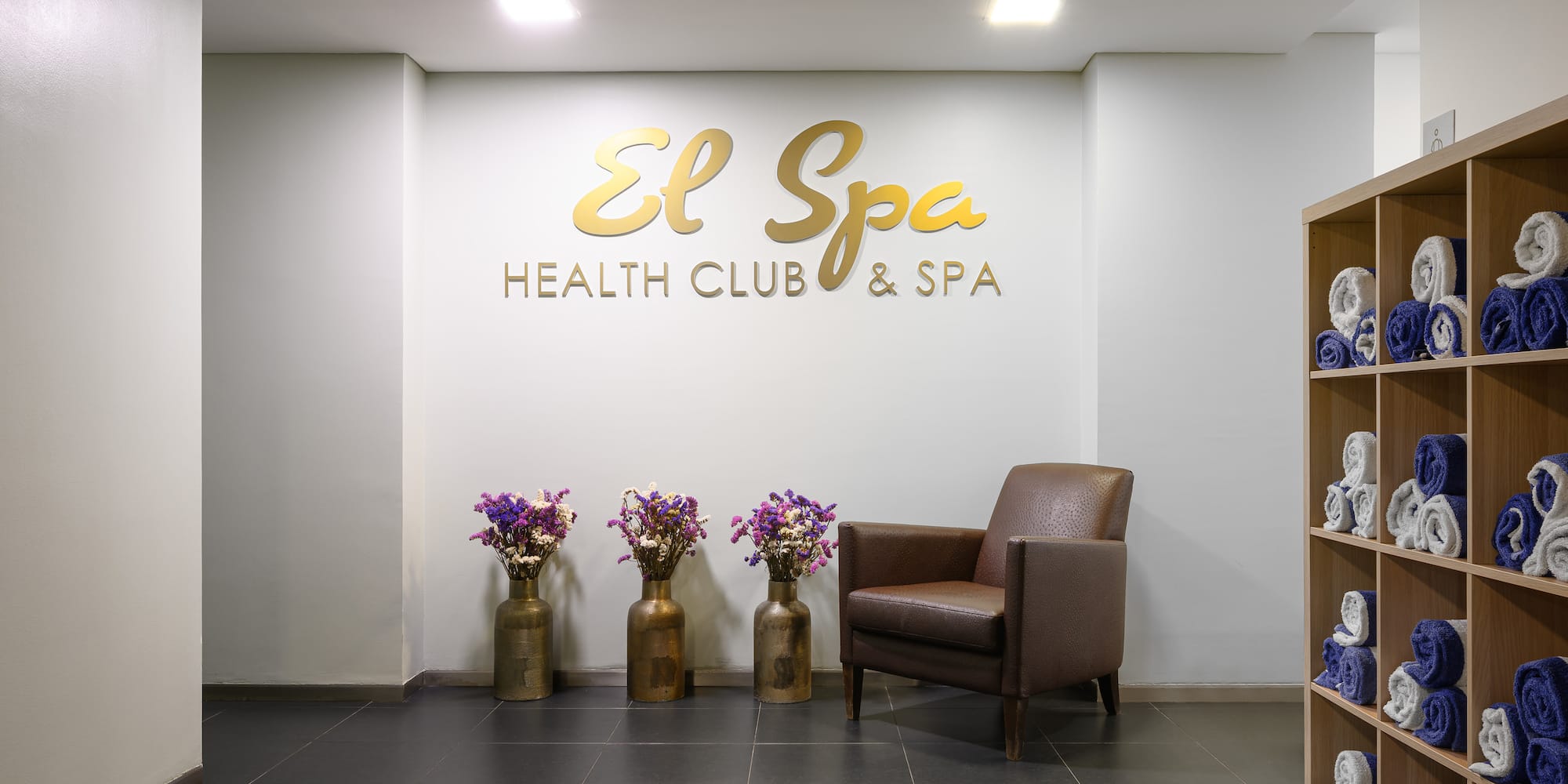 a chair and vases in front of a wall