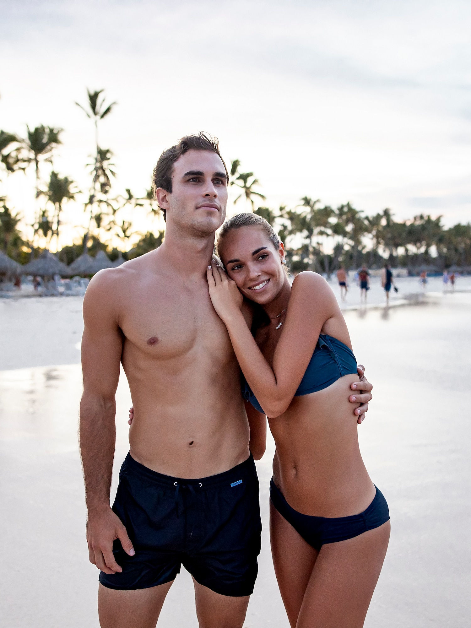 a man and woman posing for a picture on a beach